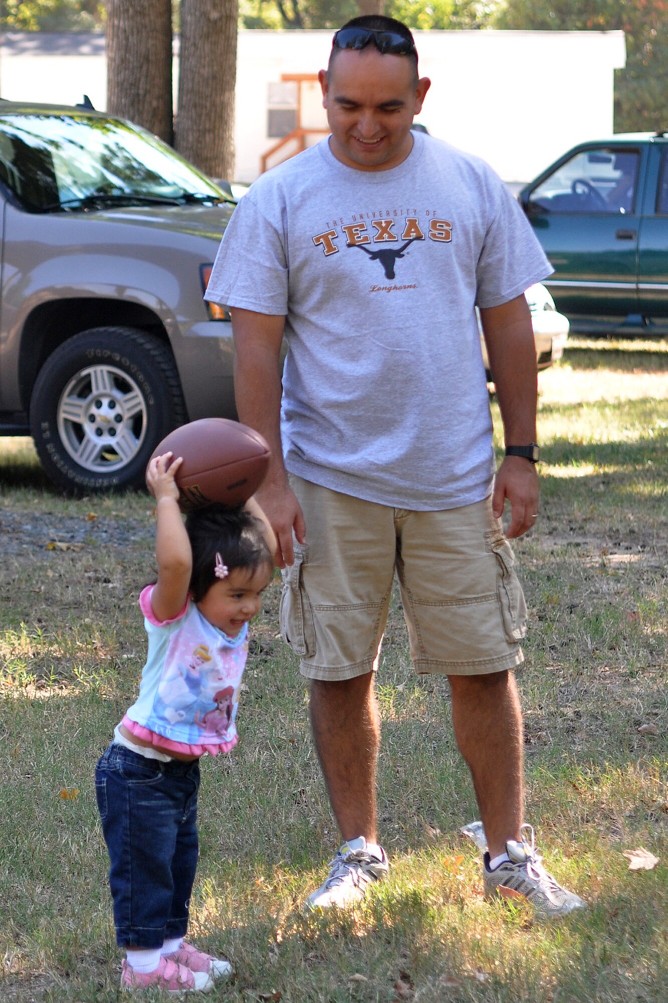 Mhia Garcia, 20 months, shows off her football skills for her father, Tech. Sgt. Joe Garcia, at the 307th Red Horse Squadron family day held at Cullen Park on Barksdale Air Force Base, La., Oct. 2, 2010. All members, families and friends were treated to an afternoon of food, fun, karaoke and camaraderie. There were also events specially designed for children, which included games, train rides and an air castle.  (Photo by Master Sgt. Mary Hinson)