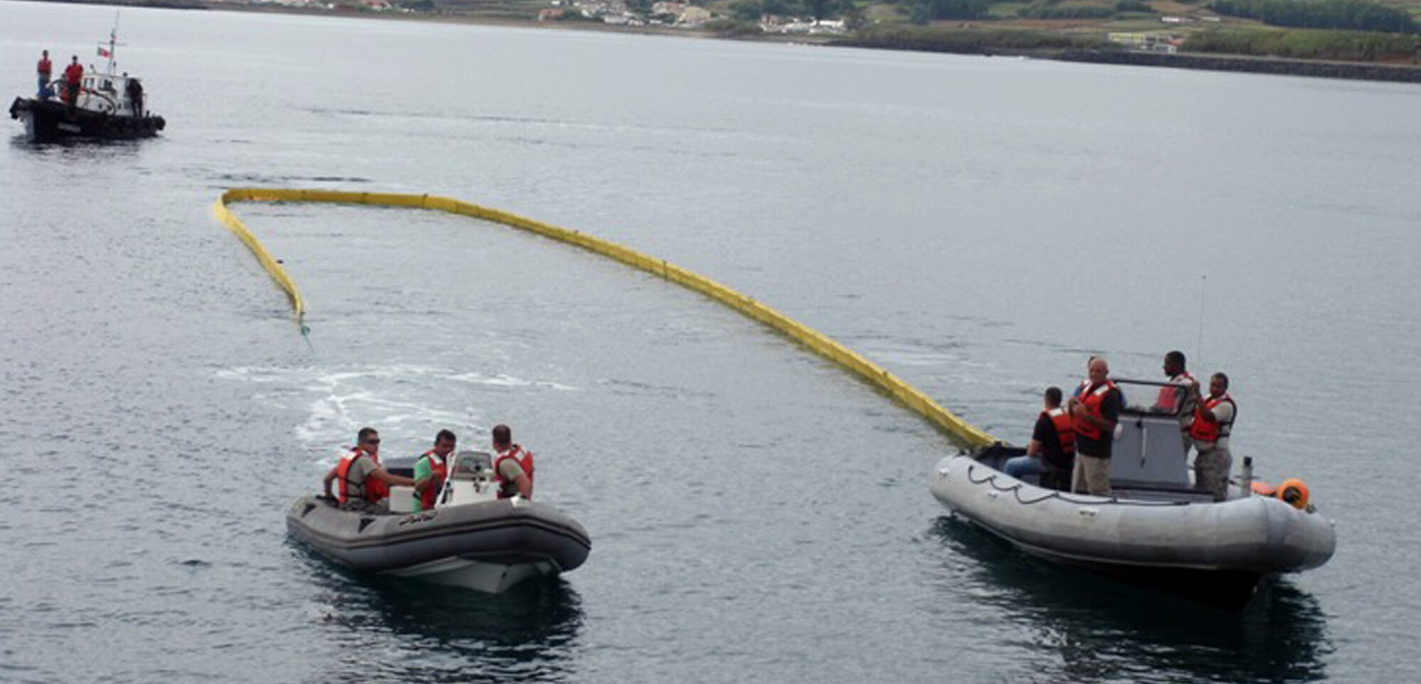 Airmen at Lajes and Portuguese officials deploy to the Priaia beach with a boom attached to two boats to contain an oil spil during a joint fuel spill response training here Sept. 28. The joint exercise brought together more than 40 U.S. and host nation’s emergency response personnel in a classroom-discussion setting and hands-on scenarios (Photo by Vitor Berbereia) 