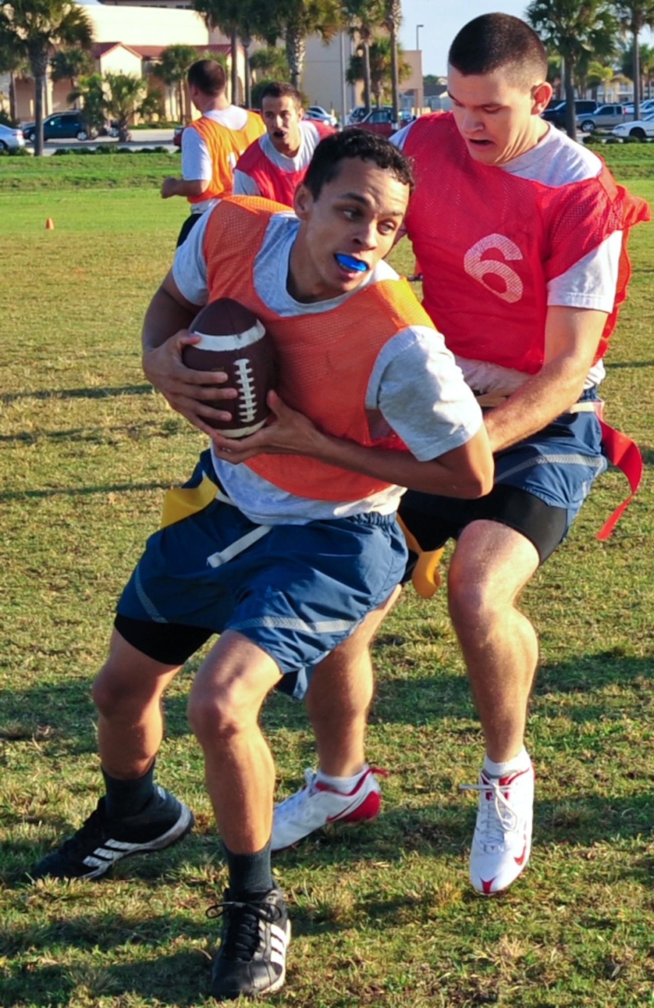 Staff Sergeant Mathew Lawrence, 45th Space Wing Civil Engineer Squadron, pulls in a pass to move the chains on Oct. 5 during the Flag Football Tournament portion of the Wing's Sports Week Competition.  Preventing the play from going for an even bigger gain, Airman First Class Wesley Stakely, 45th SW Comptroller Squadron, rips off Sergeant Lawrence's flags to finish the play.   
