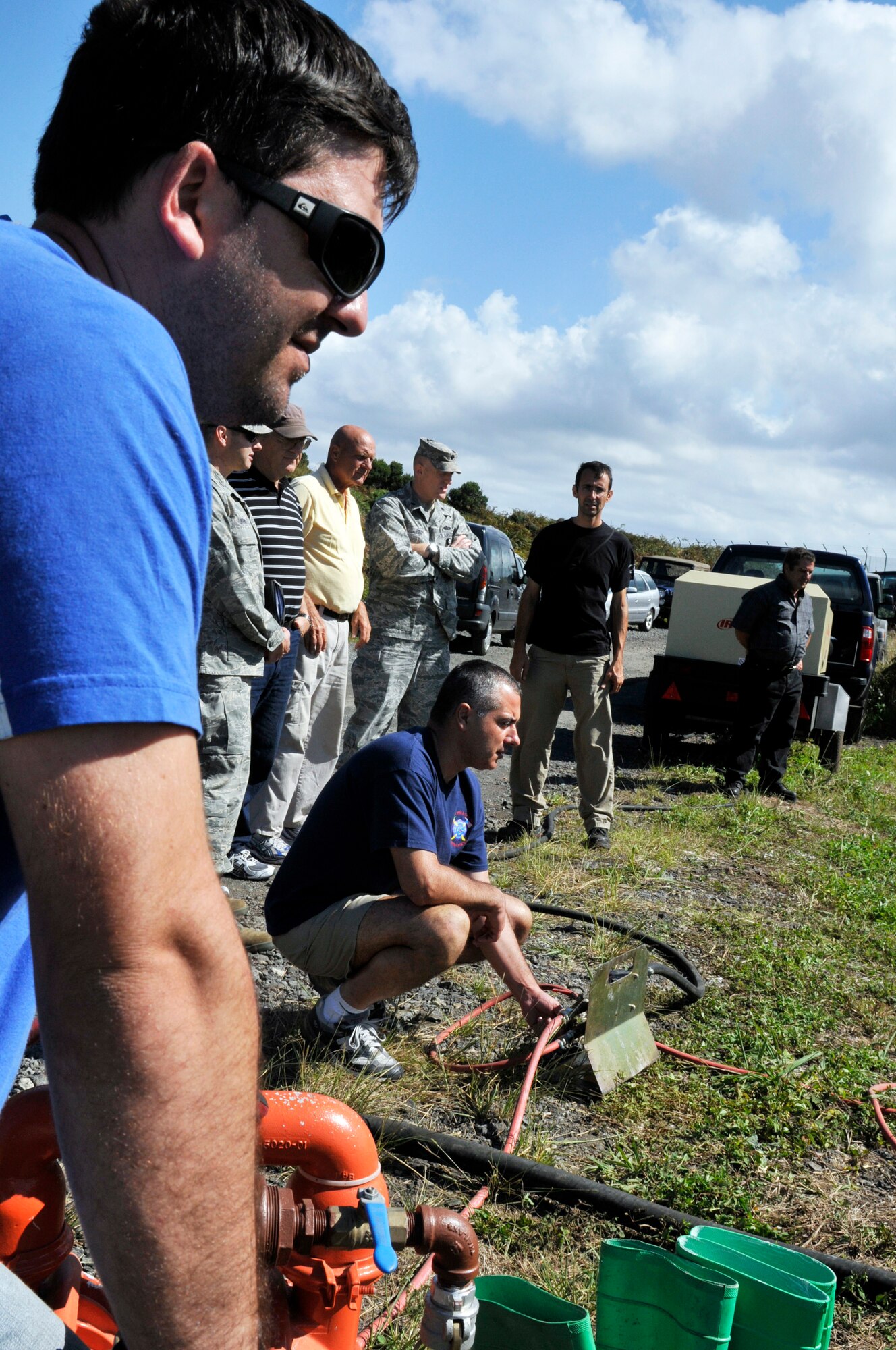 (Far left) Decio Avila and Jorge Arruda, 65th Civil Engineer Squadron, start a pump, which operates a boom and skimmer, during a land fuel spill training, as other members observe at lajes Field, Azores, Sept. 29. (Photo by Staff Sgt. Olufemi Owolabi)