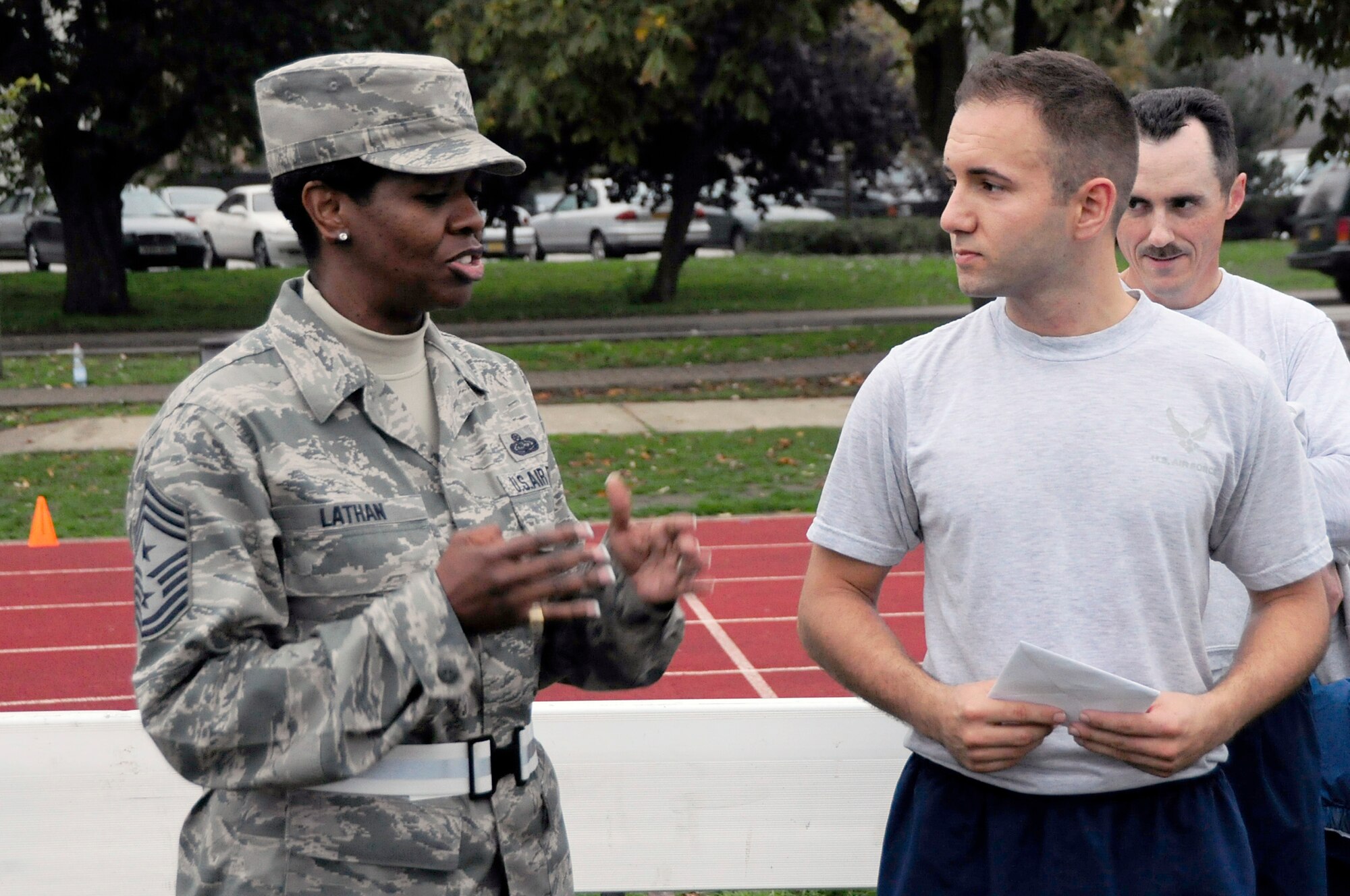 Chief Master Sgt. SaRita Lathan, 48th Fighter Wing command chief, presents Senior Airman Alexander Andrejkovics, 48th Logistics Readiness Squadron Operations and Compliance journeyman, with a coin and letter from Retired Chief Master Sgt. Pamela Derrow, former United States Air Forces in Europe command chief, after 48th LRS group physical training Oct. 8. Senior Airman Andrejkovics was one of two Airmen from the Liberty Wing to be recognized by the former command chief for outstanding performance in their jobs. (U.S. Air Force photo/Airman 1st Class Eboni Knox)

