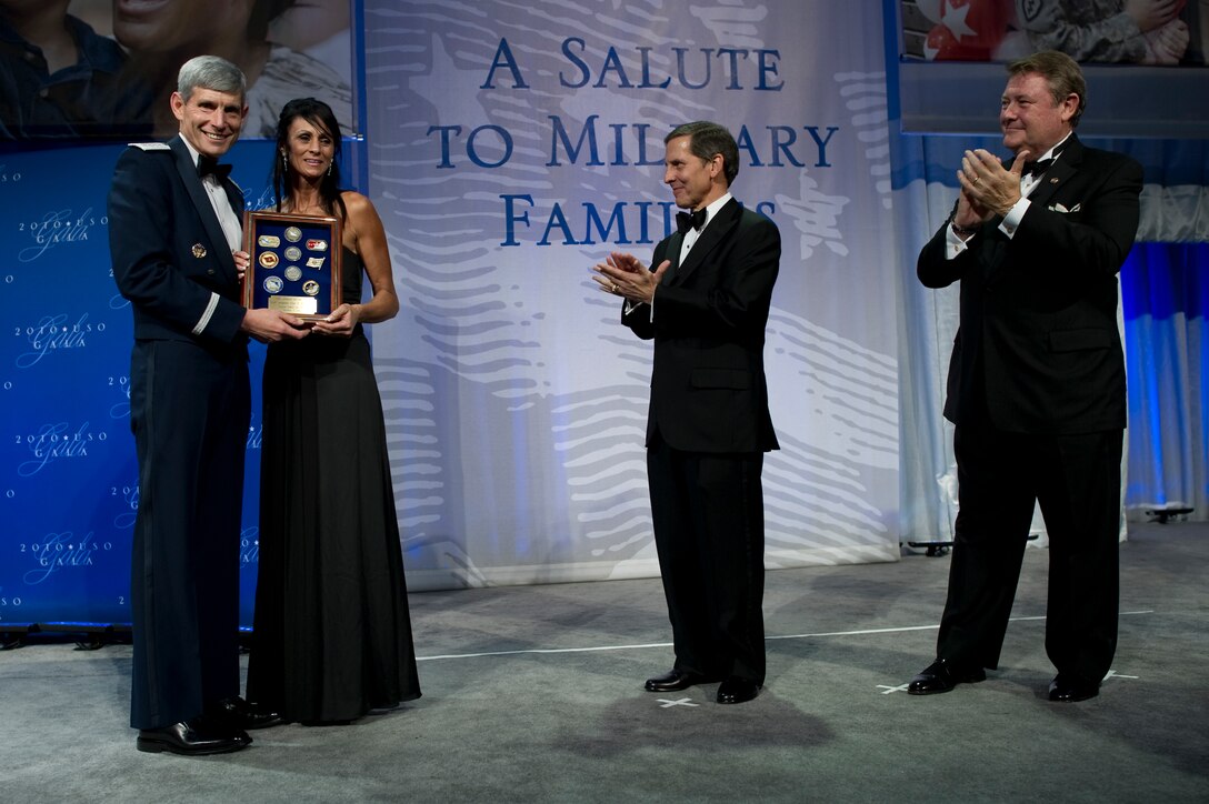 Air Force Chief of Staff Gen. Norton A. Schwartz, left, USO President Sloan Gibson, center, and Edward T. Reilly, right, president of the USO Board of Governors, present the USO Airman of the Year award to Kimberly Watkins, mother of award recipient Air Force Staff Sgt. Gino P. Kahaunaele, who is deployed, at the USO Gala in Washington, D.C., Oct. 7, 2010. DOD photo by U.S. Navy Petty Officer 1st Class Chad J. McNeeley 