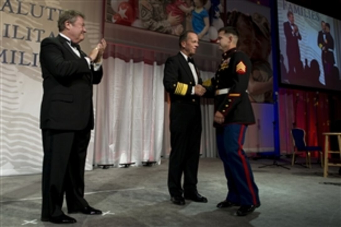 Navy Adm. Mike Mullen, chairman of the Joint Chiefs of Staff, and Edward T. Reilly, president of the USO Board of Governors, left, congratulate Marine Corps Sgt. Eric B. Walker, USO Marine of the Year, at the USO Gala in Washington, D.C., Oct. 7, 2010.