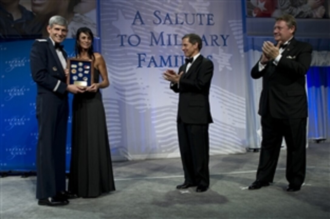 Air Force Chief of Staff Gen. Norton A. Schwartz, left, USO President Sloan Gibson, center, and Edward T. Reilly, right, president of the USO Board of Governors, present the USO Airman of the Year award to Kimberly Watkins, mother of award recpient Air Force Staff Sgt. Gino P. Kahaunaele, who is currently deployed, at the USO Gala in Washington, D.C., Oct. 7, 2010.