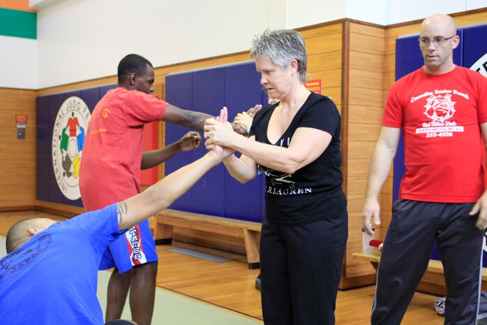 Debby Jean, self-defense class participant, practices performing a wrist lock at a selfdefense class at IronWorks Gym here Oct. 9.