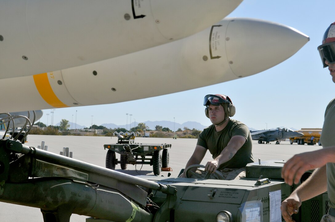 Lance Cpl. Adam Conley, Marine Tactical Electronic Warfare Squadron 4 ordnance technician, raises a high-speed, anti-radiation missile for the rest of the ordnance team to mount on an EA-6B Prowler jet at the Marine Corps Air Station in Yuma, Ariz., Oct. 8, 2010. The squadron fired a total of 14 HARMs at targets in the Pacific Ocean as part of the Weapons and Tactics Instructor course. The HARM finds its targets by detecting electromagnetic radiation and is also the only missile the Prowler jets fire.