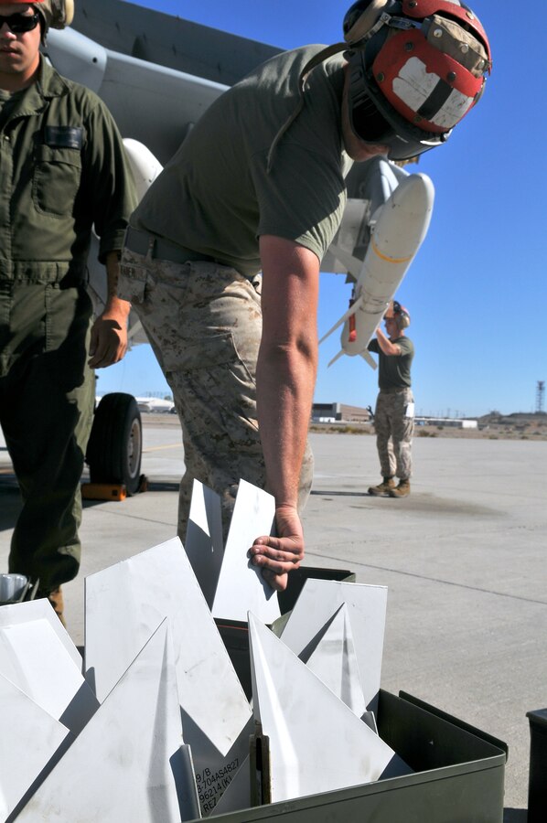 Cpl. Jared Reader, Marine Tactical Electronic Warfare Squadron 4 ordnance technician, grabs a wing attachment before locking it onto a high-speed, anti-radiation missile, which he mounted on an EA-6B Prowler jet with the rest of the VMAQ-4 ordnance team at the Marine Corps Air Station in Yuma, Ariz., Oct. 8, 2010. The Prowler jets fired a total of 14 HARMs at targets in the Pacific Ocean, as part of the Weapons and Tactics Instructor course in Yuma. The Cherry Point, N.C.-based squadron specializes in electronic warfare using the HARM, which detects electromagnetic radiation given off by enemy radars or anti-aircraft weapons, and is also the only missile Prowlers launch.