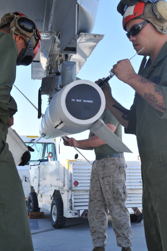 Pfc. Devlen Polite, left, and Lance Cpl. Bryce Morgan, Marine Tactical Electronic Warfare Squadron 4 ordnance technicians, attach fins to a high-speed, anti-radiation missile, after mounting it on an EA-6B Prowler jet with the rest of the VMAQ-4 ordnance team at the Marine Corps Air Station in Yuma, Ariz., Oct. 8, 2010. The Cherry Point, N.C.,-based squadron specializes in electronic warfare using the HARM, which detects electromagnetic radiation given off by enemy radars or anti-aircraft weapons, and is also the only missile Prowlers launch.