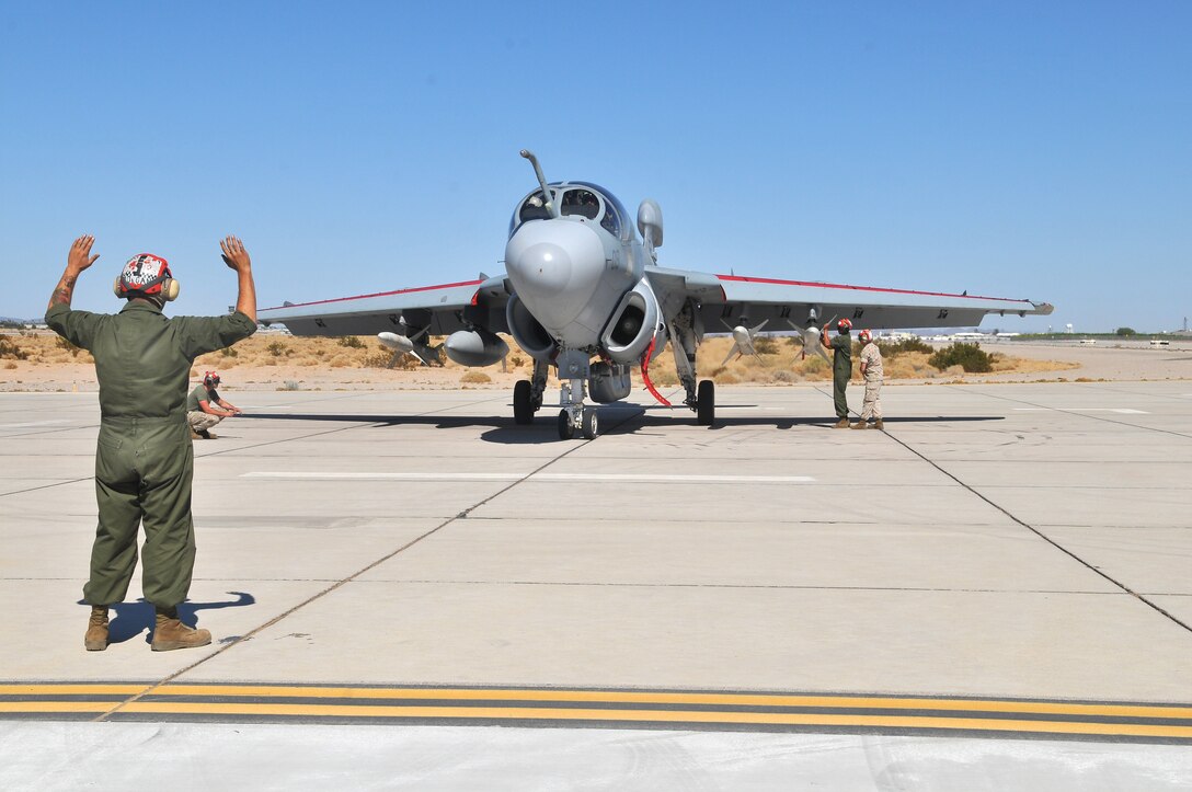 Lance Cpl. Bryce Morgan, Marine Tactical Electronic Warfare Squadron 4 ordnance technician, communicates signals to the EA-6B Prowler jet crew, while Pfc. Devlen Polite, VMAQ-4 ordnance technician, and Staff Sgt. Robert Farmer, VMAQ-4 ordnance chief, arm the high-speed, anti-radiation missiles they mounted on the jet at the Marine Corps Air Station in Yuma, Ariz., Oct. 8, 2010. The Cherry Point, N.C.,-based squadron fired a total of 14 HARMs at targets in the Pacific Ocean as part of the Weapons and Tactics Instructor course. The HARM finds its targets by detecting electromagnetic radiation and is also the only missile the Prowler jets fire.