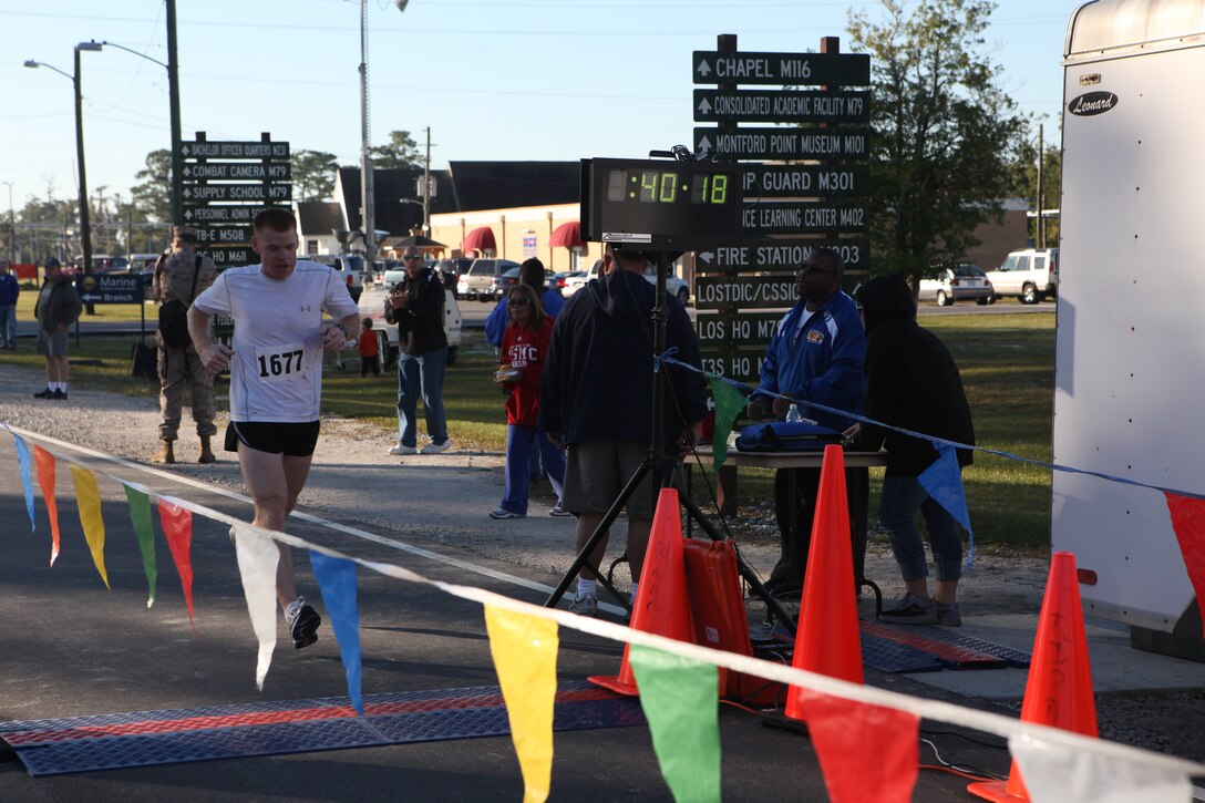 Matt Chambliss, the first place overall male winner, crosses the finish line in 40 minutes, 18 seconds during the Marine Corps Community Services’ Beirut Memorial 10K race aboard Camp Johnson, Oct. 9.  Service members, families, retired military personnel, civilians and children participated in the 6.2-mile race in honor of those who lost their lives in the Beirut bombings on Oct. 23, 1983.