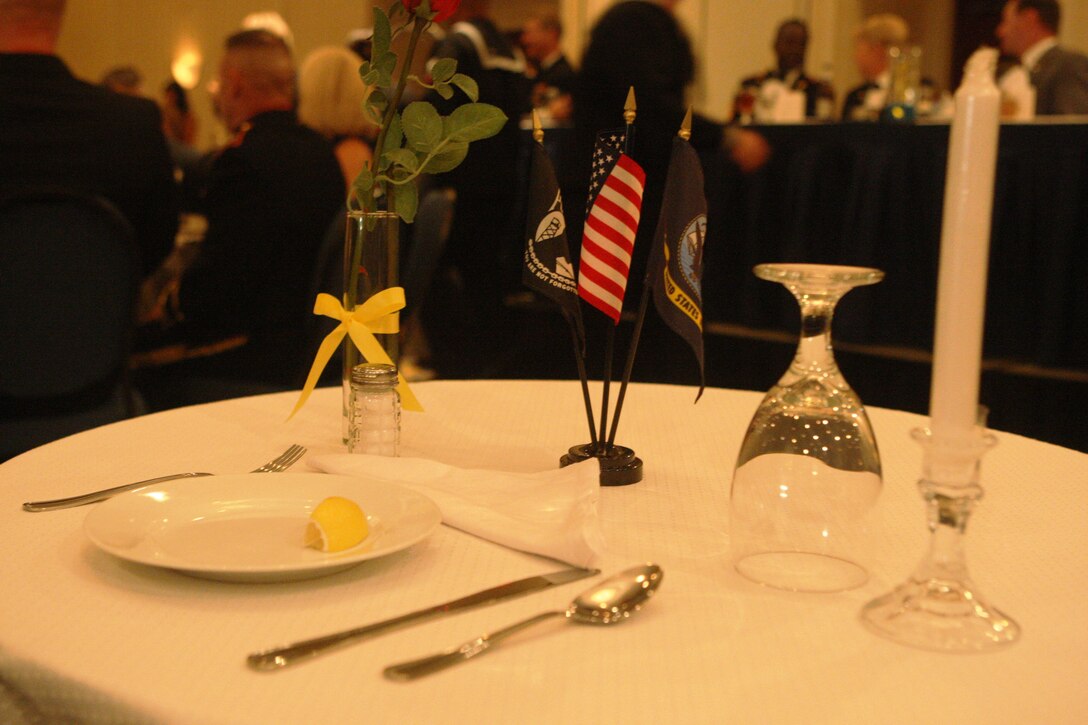 A table on honor of all Prisoners of War/Missing in Action service members is set up for those who are still missing during the United States Navy's 235th Birthday at the Sheraton Oceanfront Hotel in Atlantic Beach, N.C., Oct. 9. The night's theme, "transcending through time," was further exemplified as the youngest sailors interacted with the oldest veterans on this special occasion.