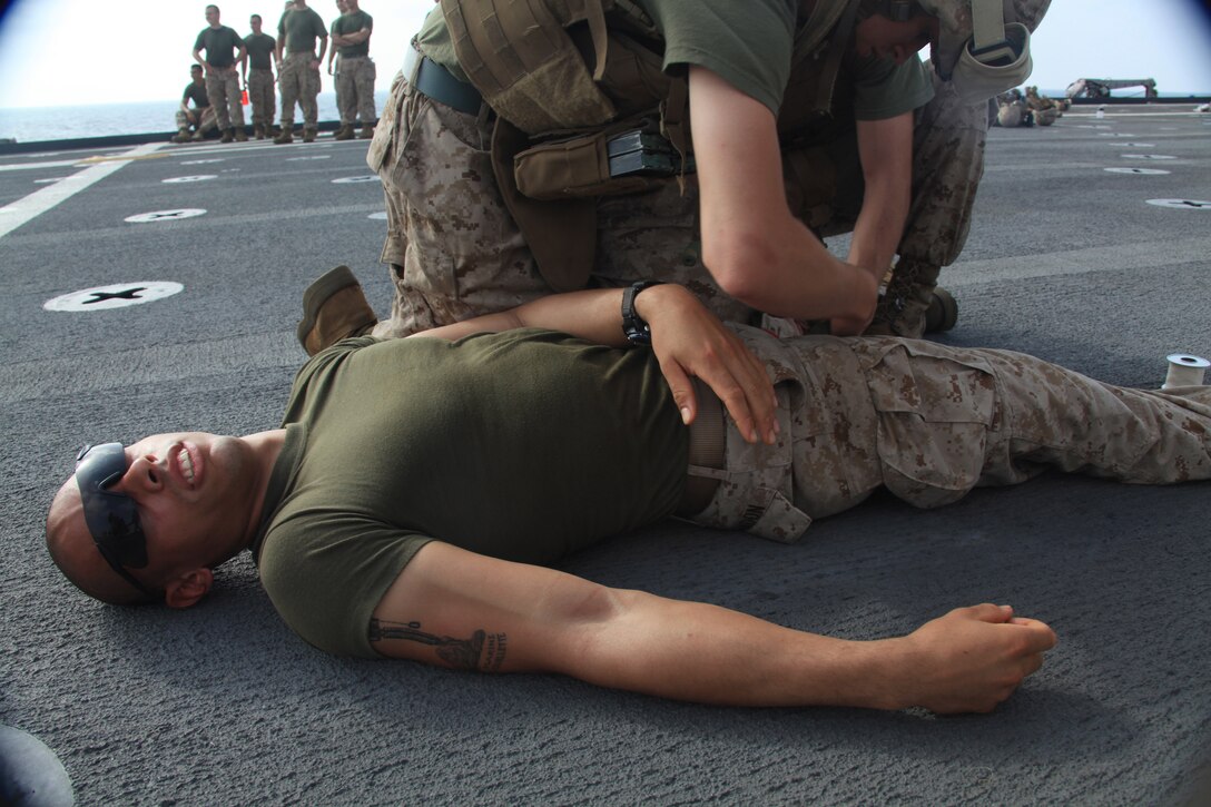 Lance Cpl. Marcus Landon, an infantryman with 2nd Platoon, K Company, Battalion Landing Team 3/8, 26th Marine Expeditionary Unit, acts as an injured Marine with a femoral artery laceration on the flight deck of USS Ponce in the U.S. Navy Fifth Fleet Area of Responsibility, Oct. 9, 2009. 26th MEU continues to support relief operations in Pakistan and is also serving as the U.S. Central Command theater reserve force as elements of the MEU conduct training and planned exercises.