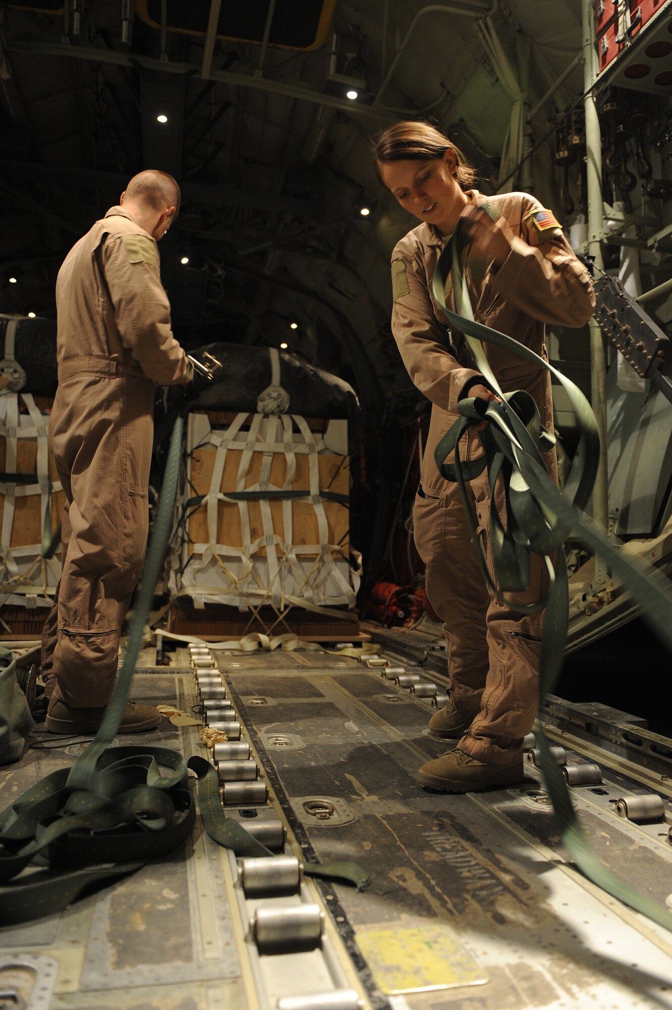 Staff Sgt. T.J. Grover and Airman 1st Class Rachael Orazine prepare to strap airdrop bundles in a C-130J Hercules Oct. 5, 2010, at Kandahar Airfield, Afghanistan.  Sergeant Grover and Airman Orazine are loadmasters assigned to the 772nd Expeditionary Airlift Squadron. (U.S. Air Force photo by Tech. Sgt. Chad Chisholm/Released)