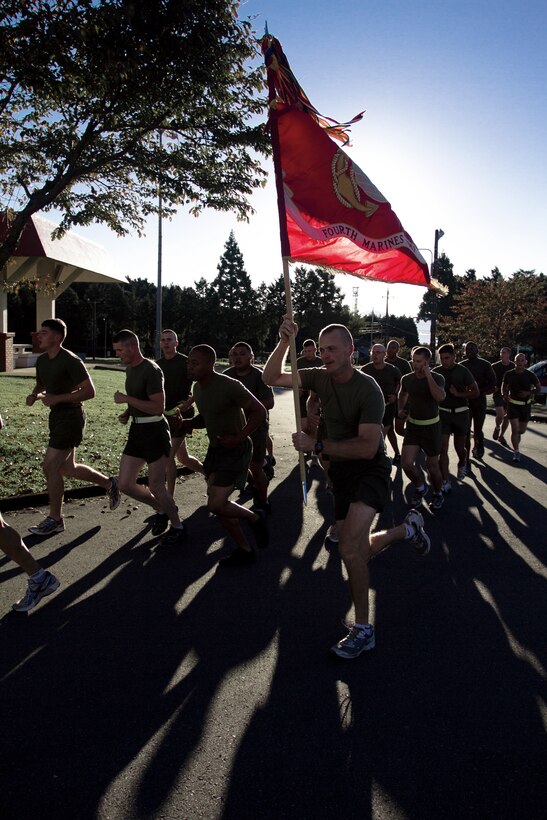 Staff Sgt. Benjamin Barron carries the regimental colors during a 4th Marine Regiment, 3rd Marine Division, III Marine Expeditionary Force, run at Combined Arms Training Center, Camp Fuji, Oct. 11.