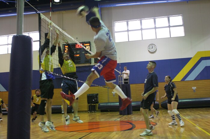 Jordan Kroell, player for Team IDK, smashes the volleyball down as Kazutoshi Sayamoto and Kouichi Nakatawa, players for the Merry’s, jump in an attempt to defend their side of the net at the five-on-five volleyball tournament hosted at the IronWorks Gym Sunday. The Merry’s were champions of the tournament after fiercely battling against Team IDK in three close matches.
