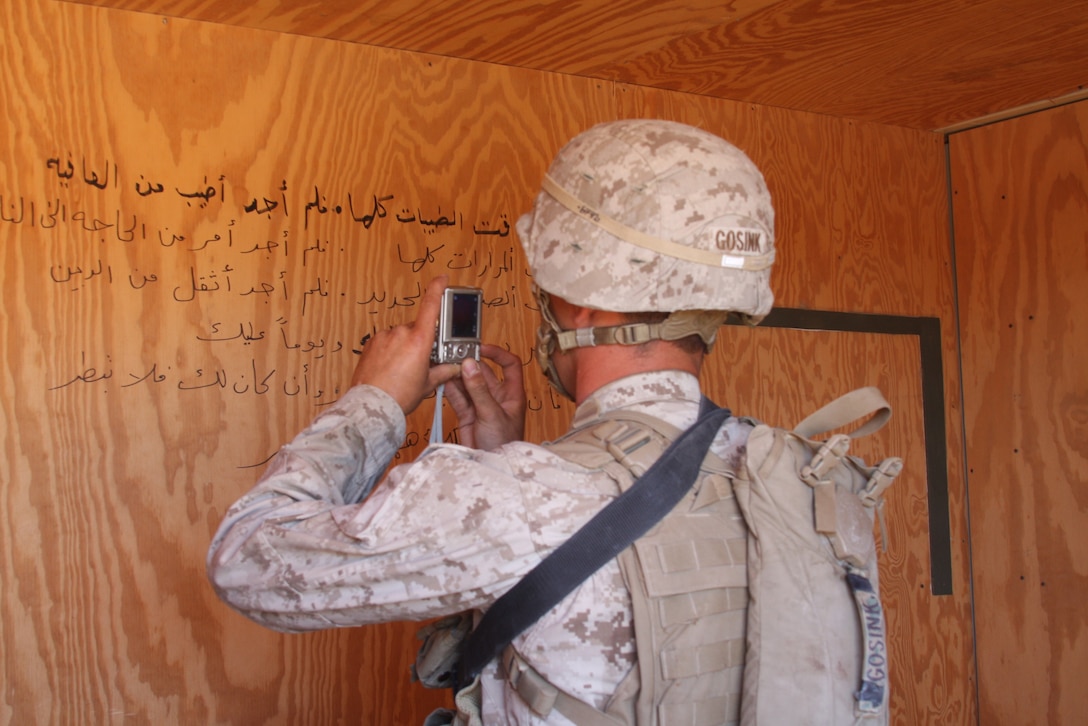 MARINE CORPS AIR GROUND COMBAT CENTER TWENTYNINE PALMS, Calif. – Lance Cpl. Andrew Gosink, a rifleman with Company G, 2nd Battalion, 4th Marine Regiment, based out of Marine Corps Base Camp Pendleton, Calif., catalogs writing on the wall during exercise Steel Knight at Combat Center Range 215 Oct. 11. Steel Knight is a combined arms exercise incorporating more than 5,000 Marines and sailors. (U.S. Marine Corps photo by Lance Cpl. William J. Jackson)::r::::n::