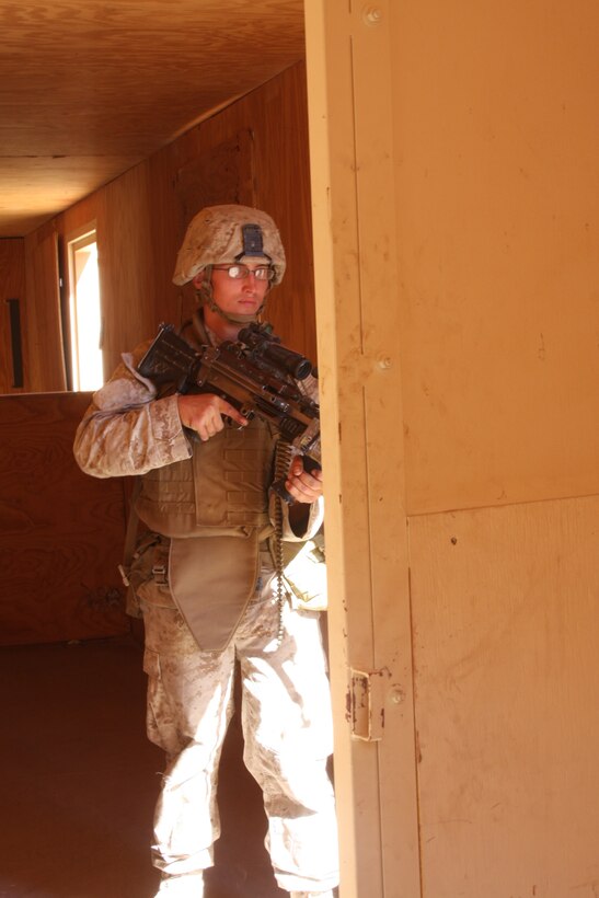 MARINE CORPS AIR GROUND COMBAT CENTER TWENTYNINE PALMS, Calif. – Corporal Christopher Mansfield, a squad automatic weapon gunner with Company G, 2nd Battalion, 4th Marine Regiment, based out of Marine Corps Base Camp Pendleton, Calif., checks a doorway while clearing a building at Combat Center Range 215 Oct. 11. The Marines are training during Exercise Steel Knight for their upcoming deployment with the 11th Marine Expeditionary Unit. (U.S. Marine Corps photo by Lance Cpl. William J. Jackson)::r::::n::