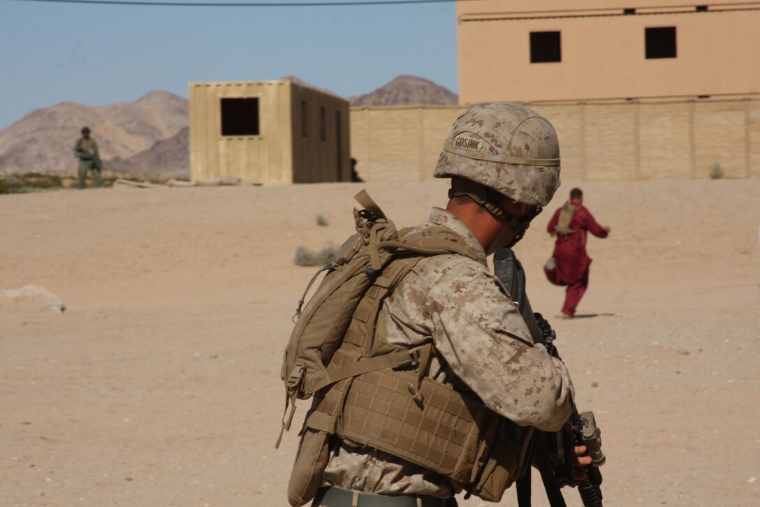 MARINE CORPS AIR GROUND COMBAT CENTER TWENTYNINE PALMS, Calif. – Lance Cpl. Andrew Gosink, a rifleman with Company G, 2nd Battalion, 4th Marine Regiment, based out of Marine Corps Base Camp Pendleton, Calif., wards of a role player after declaring a building clear during Exercise Steel Knight Oct. 11. The Marines and sailors went through squad live-fire attacks, mechanized attacks, counterinsurgency and military operations on urbanized terrain training to get ready for their upcoming deployment with the 11th Marine Expeditionary Unit. (U.S. Marine Corps photo by Lance Cpl. William J. Jackson)::r::::n::