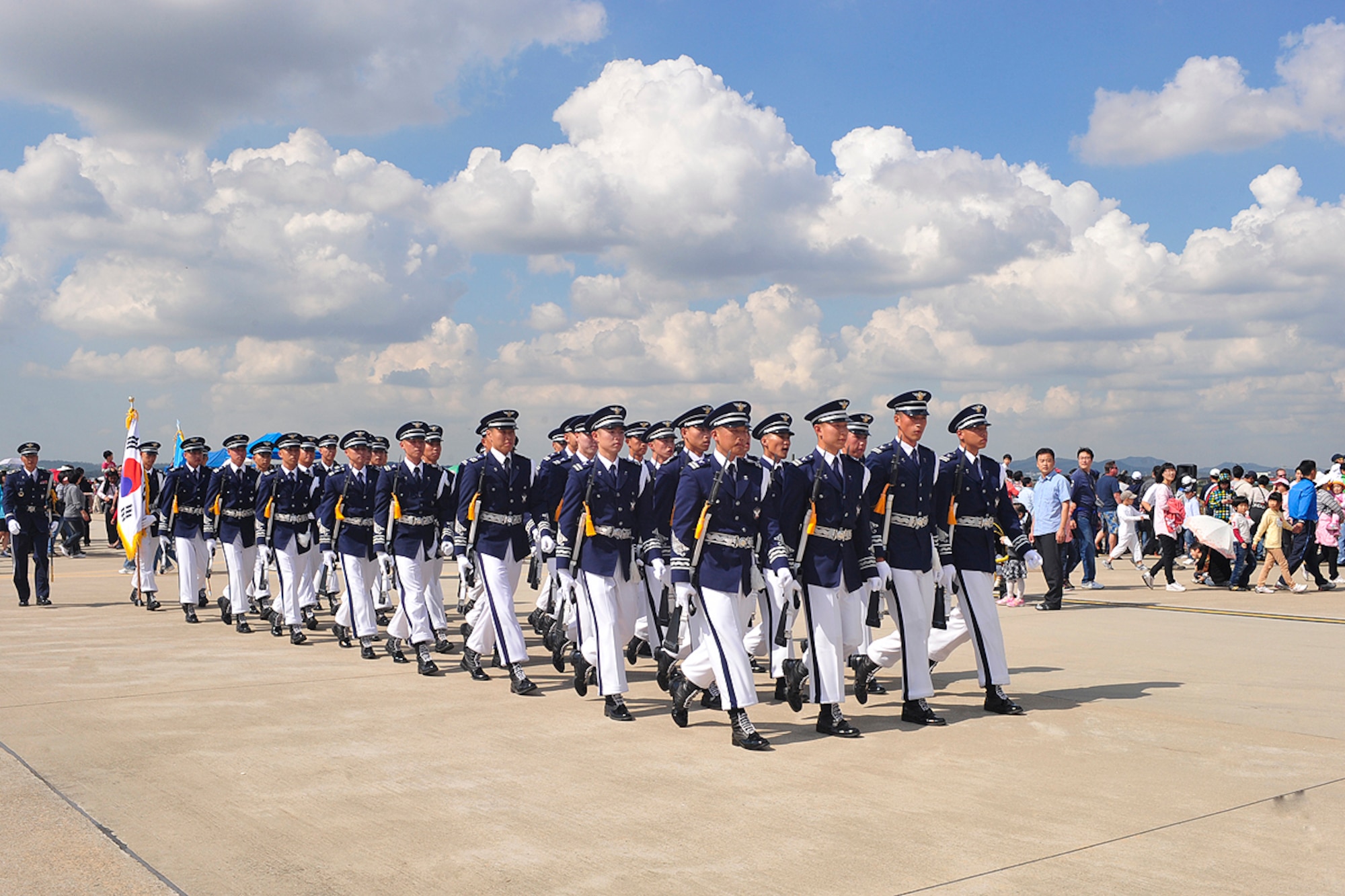 A Republic of Korea Air Force drill team marches through the crowd during the 8th Annual Air Power Day at Osan Air Base Oct. 9. The team was one of many to support the event. The event included a variety of Korean and American high performance aerial demonstrations, unique ground performances, military equipment static displays, a children's play area and a wide variety of food and souvenir booths. (U.S. Air Force photo/Staff Sgt. Eunique Stevens)