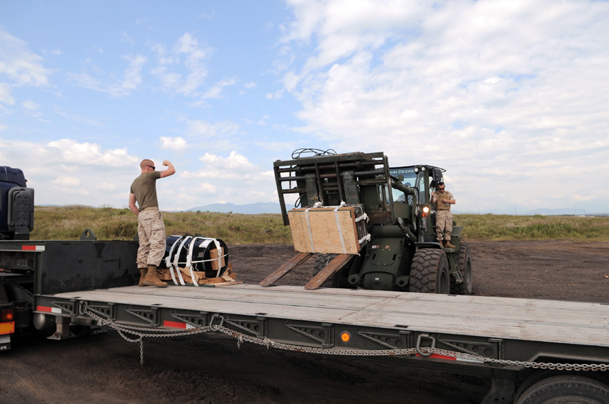 YOKOTA AIR BASE, Japan -- Marines from Camp Fuji load larger cargo dropped out of a C-130 Hercules onto truck, here Oct. 7. The Marines helped Airmen from Yokota collect heavier cargo after a practice of the new Low Cost, Low Altitude drop technique at the Fuji Drop Zone. (U.S. Air Force Photo/Airman 1st Class Katrina R. Menchaca)
