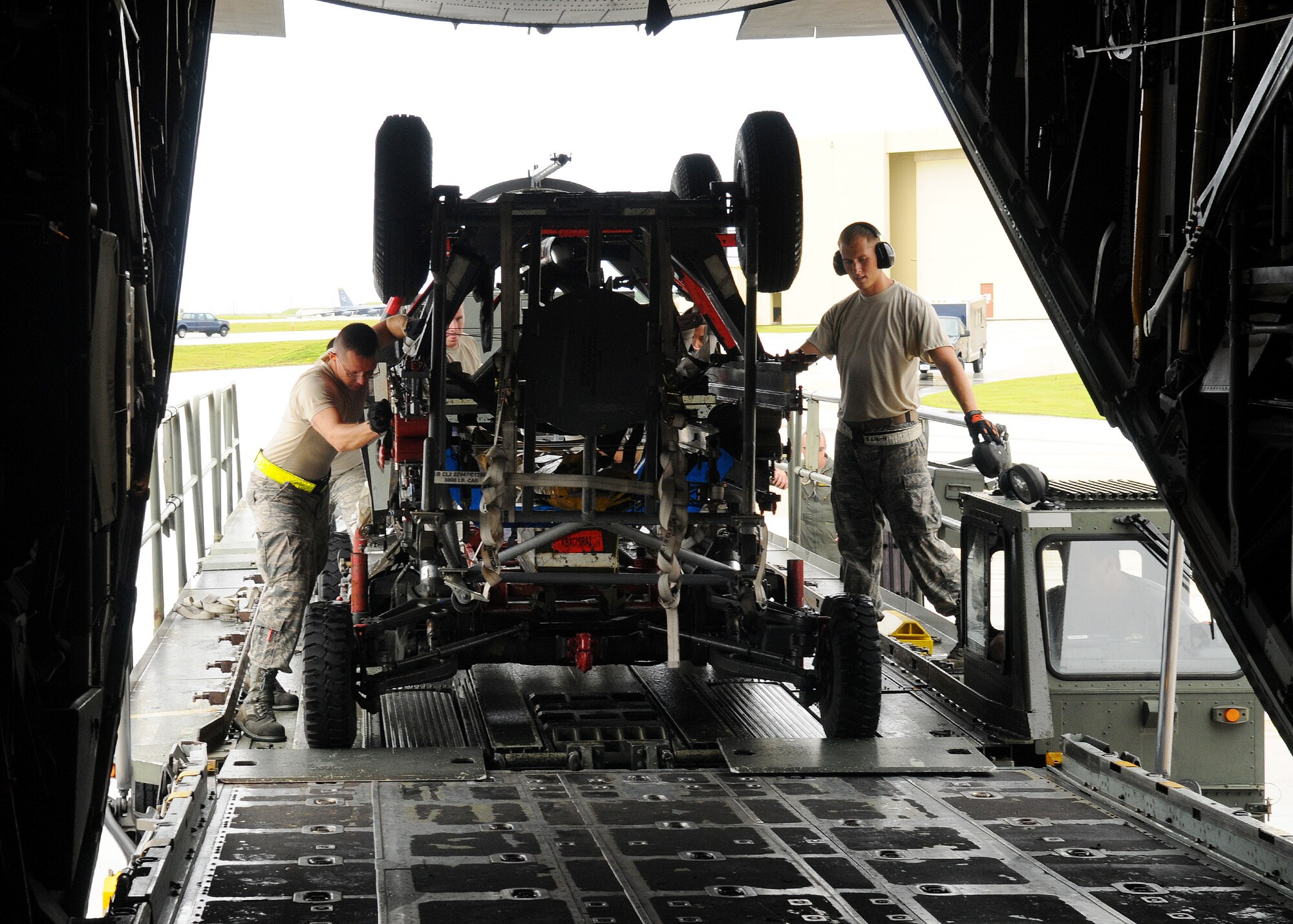 Airman 1st Class James Weimer and Staff Sgt. Allen Rees, 734th Air Mobility Squadron aerial porters, load equipment used for Valiant Shield 2010 on a C-130 Hercules at Andersen Air Force Base, Guam, Sept. 30. (U.S. Air Force photo/ Senior Airman Nichelle Anderson)
