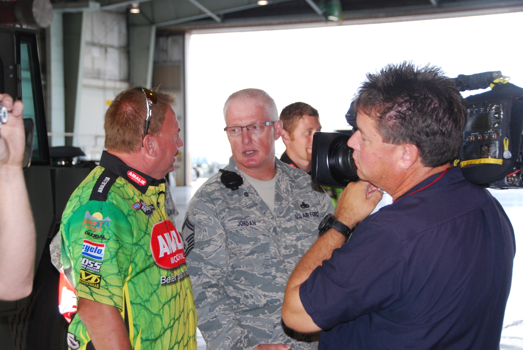 Mr. Matt Ilas, ESPN videographer/producer on-site, gives race attendees and viewers a look into the similarities and differences in maintaining a fighter jet and a Top Fuel dragster.  Senior Master Sgt. Paul Jordan, 301st Maintenance Squadron inspection flight chief, explains the inspection process to Mr. Terry McMillen, driver of the Amalie Oil Top Fuel dragster. McMillen and his crew recently visited the 301st Fighter Wing before racing at a Dallas-area event. ESPN was on hand to record the visit between the two “high horsepower” professions. (Air Force Photo/Tech. Sgt. Shawn McCowan)