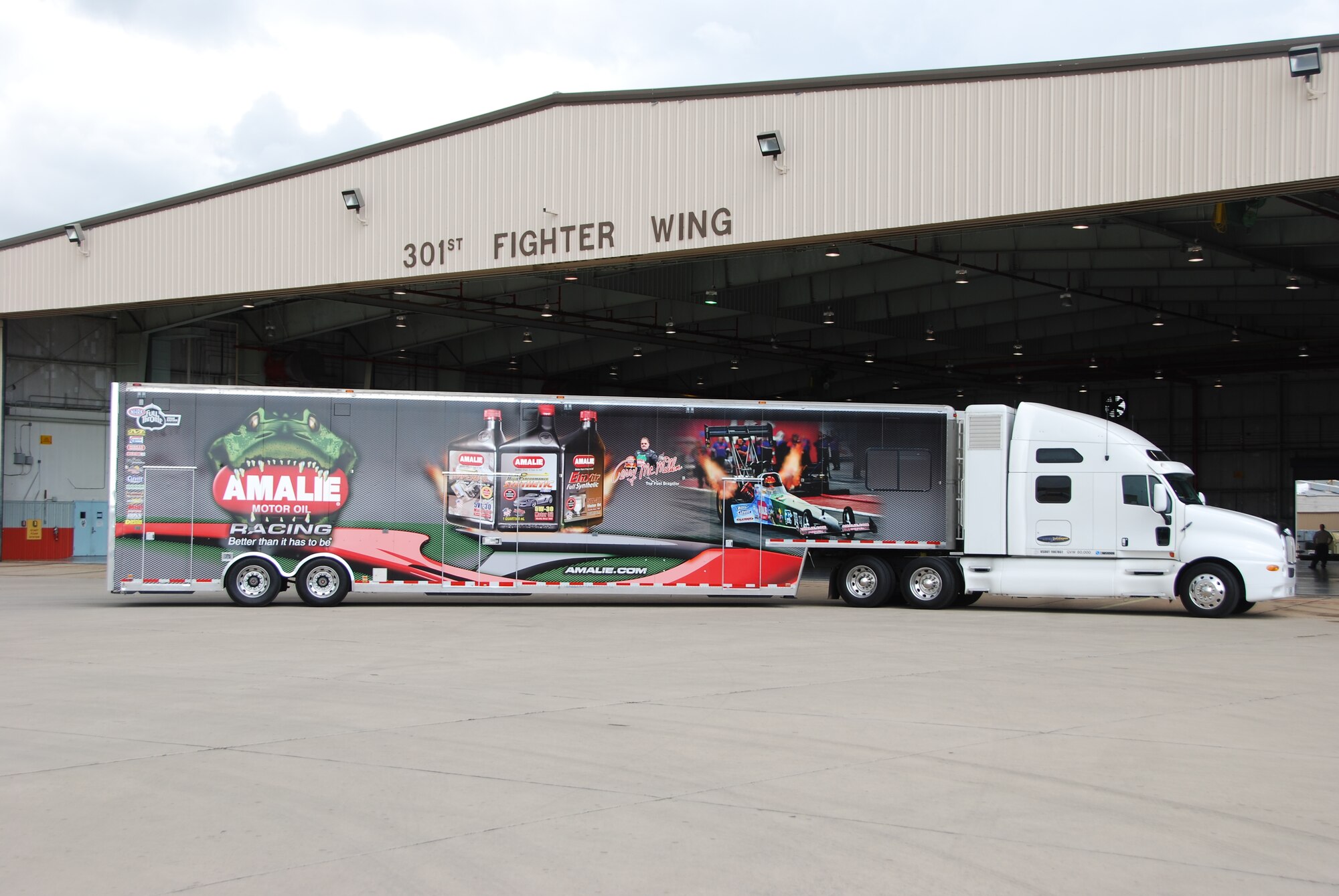 Semi belonging to Mr. Terry McMillen, driver of the Amalie Oil Top Fuel dragster, pulls up in front the of 301st Fighter Wing hangar as the crew prepares to assemble the dragster for the next morning’s demonstration. McMillen and his crew recently visited the 301st Fighter Wing before racing at a Dallas-area event. (Air Force Photo/Tech. Sgt. Shawn McCowan)