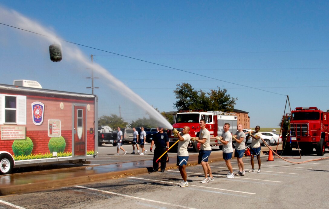 The team from the 82nd Medical Group uses a fire hose to spray a ball across a high wire Oct. 8 during the inaugural Sheppard Fire Department Firefighter Olympics. The 362nd Training Squadron team was crowned the champions of the first event, followed by the 82nd MDG. (U.S. Air Force photo/Mike Litteken)