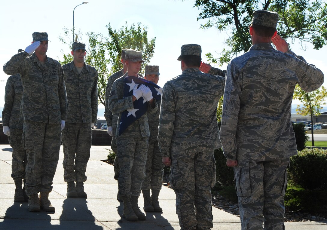 ELLSWORTH AIR FORCE BASE, S.D. -- Base Honor Guard Airmen present the American flag to Col. Jeffrey Taliaferro, 28th Bomb Wing commander, during the prisoner of War/Missing in Action retreat ceremony, Oct. 1.  Ellsworth Airmen honor and remember all those under POW/MIA status which is approximately 100,000 service-members. (U.S. Air Force photo/Airman 1st Class Anthony Sanchelli)
