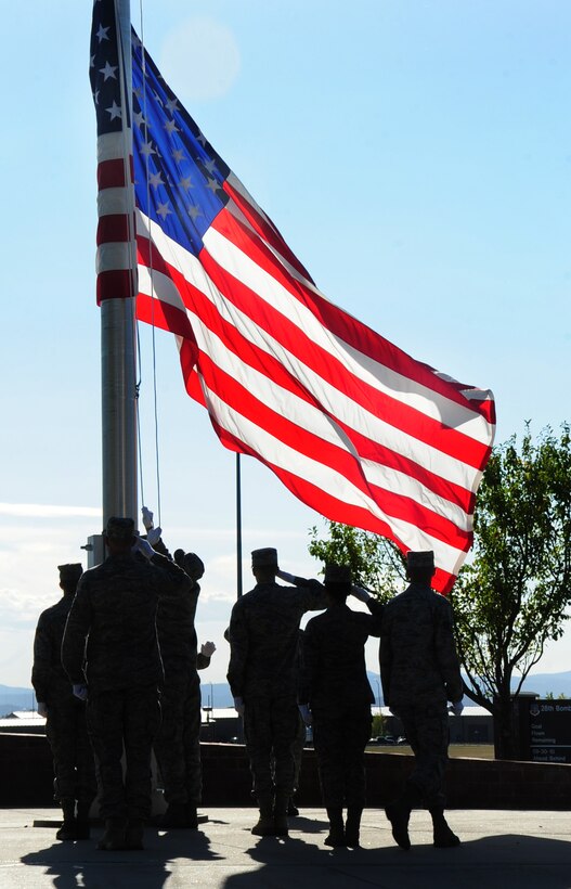 ELLSWORTH AIR FORCE BASE, S.D. -- Base Honor Guard Airmen salute the American flag as it is lowered during the Prisoner of War/Missing in Action retreat ceremony, Oct. 1.  Ellsworth Airmen participated in a 5k remembrance run, a motorcycle ride to the Black Hills National Cemetery as well as participate in the POW/MIA retreat ceremony. (U.S. Air Force photo/Airman 1st Class Anthony Sanchelli)
