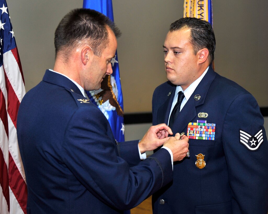 Colonel Ken Rizer, 11th Wing commander, pins the Purple Heart medal to Staff Sgt. David Veros, 11th Security Forces Squadron training instructor, during a ceremony at Joint Base Andrews Md., Oct 7, for wounds received Nov 17, 2007.  The Purple Heart medal is presented to members of the U.S. Armed Forces who are wounded by an instrument of war in the hands of the enemy.  (U.S. Air Force photo by Staff Sgt. Christopher A. Marasky)