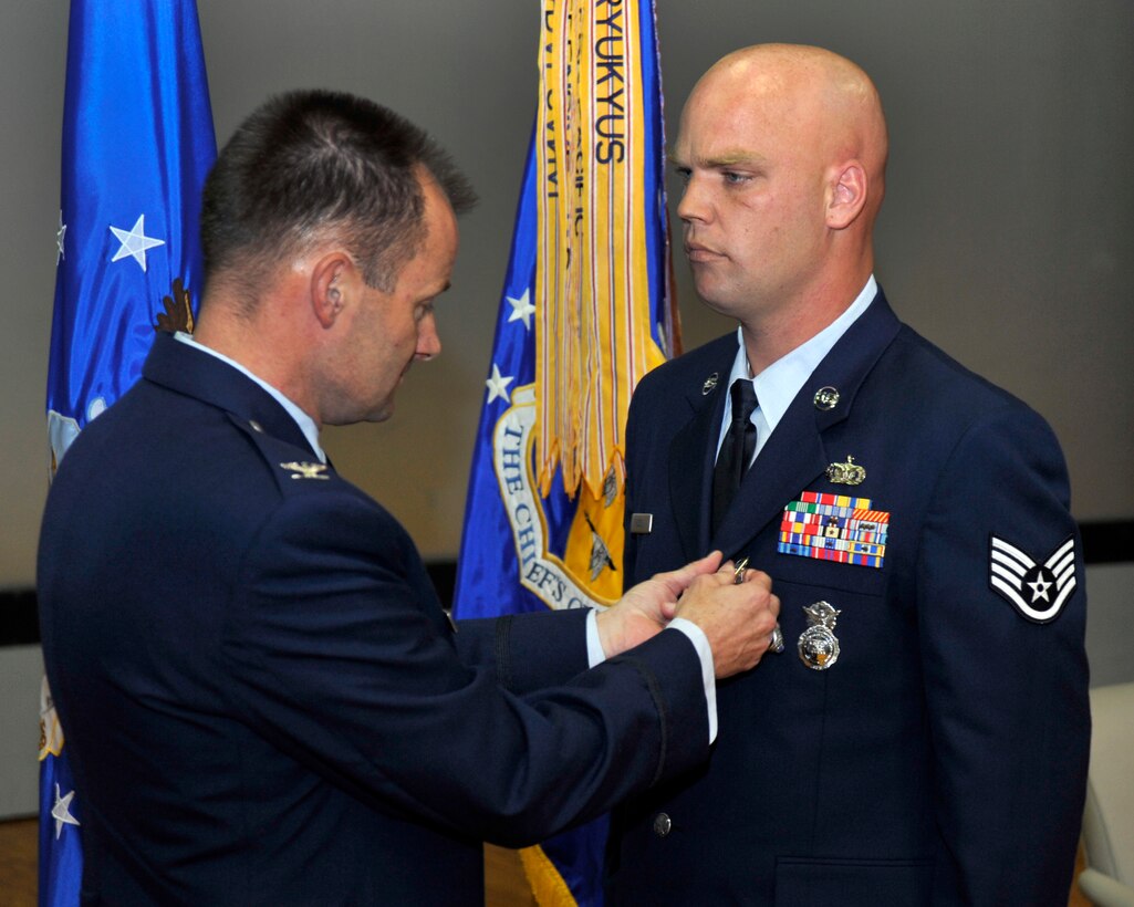 Colonel Ken Rizer, 11th Wing commander, pins the Bronze Star medal to Staff Sgt. Larry Russell, 11th Security Forces Squadron protective service member, for his meritorious actions while deployed to Iraq, during a ceremony at Joint Base Andrews Md., Oct 7.  Sergeant Russell distinguished himself during his deployment to the 532nd Air Expeditionary Security Forces, Balad Air Base, Iraq, from Aug 2009 through February 2010.  (U.S. Air Force photo by Staff Sgt. Christopher A. Marasky)