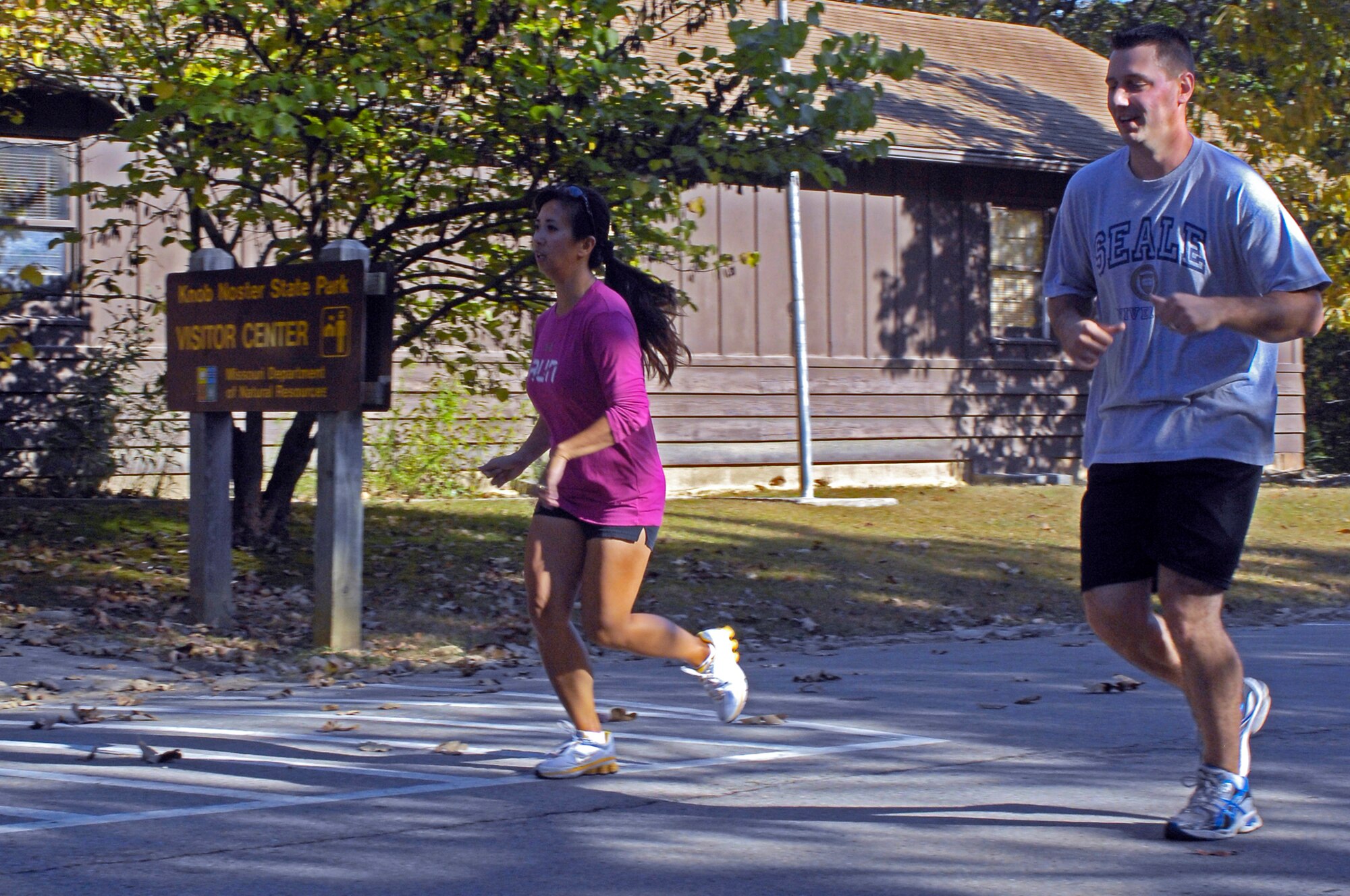 WHITEMAN AIR FORCE BASE, Mo. - Staff Sgt. Dustin Seale, 509th Munitions Squadron (right), and Mrs. Farrah Thompson, Extreme Military Training coach, run  Oct. 8 through Knob Noster State Park during an EMT session. Mrs. Thompson performs most workouts with her students and provides instruction for proper form on exercises. (U.S. Air Force photo/Senior Airman Jason Barebo)