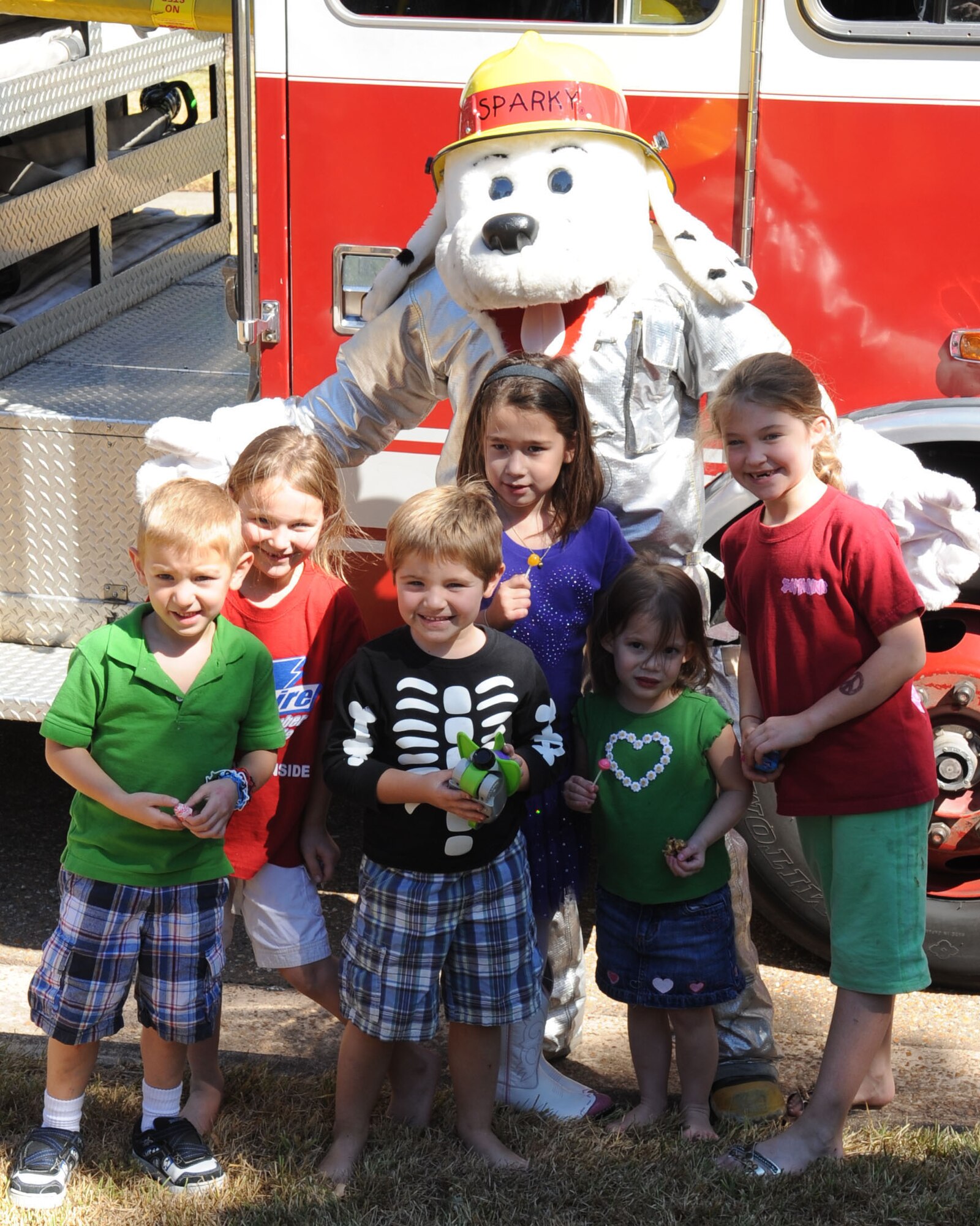 BARKSDALE AIR FORCE, La. -- Fire mascot, Sparky the Fire Dog, takes a photo with children Oct. 3 during a ride through main base housing for Fire Prevention Week. The fire department urged residents when to check their smoke detectors and displayed the proper way to check and use their fire extinguishers. (U.S. Air Force photo/Airman 1st Class Sean Martin)(Released)
