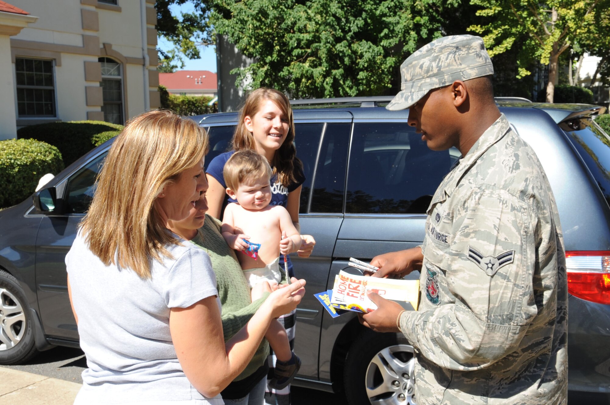 BARKSDALE AIR FORCE BASE, La. -- Airman 1st Class Jermol Edwards, 2nd Civil Engineer Squadron firefighter, hands out fire safety pamphlets to main base housing residents Oct. 3 during Fire Prevention Week. The fire department urged residents to check their smoke detectors and displayed the proper way to check and use their fire extinguishers. (U.S. Air Force photo/Airman 1st Class Sean Martin)(Released)