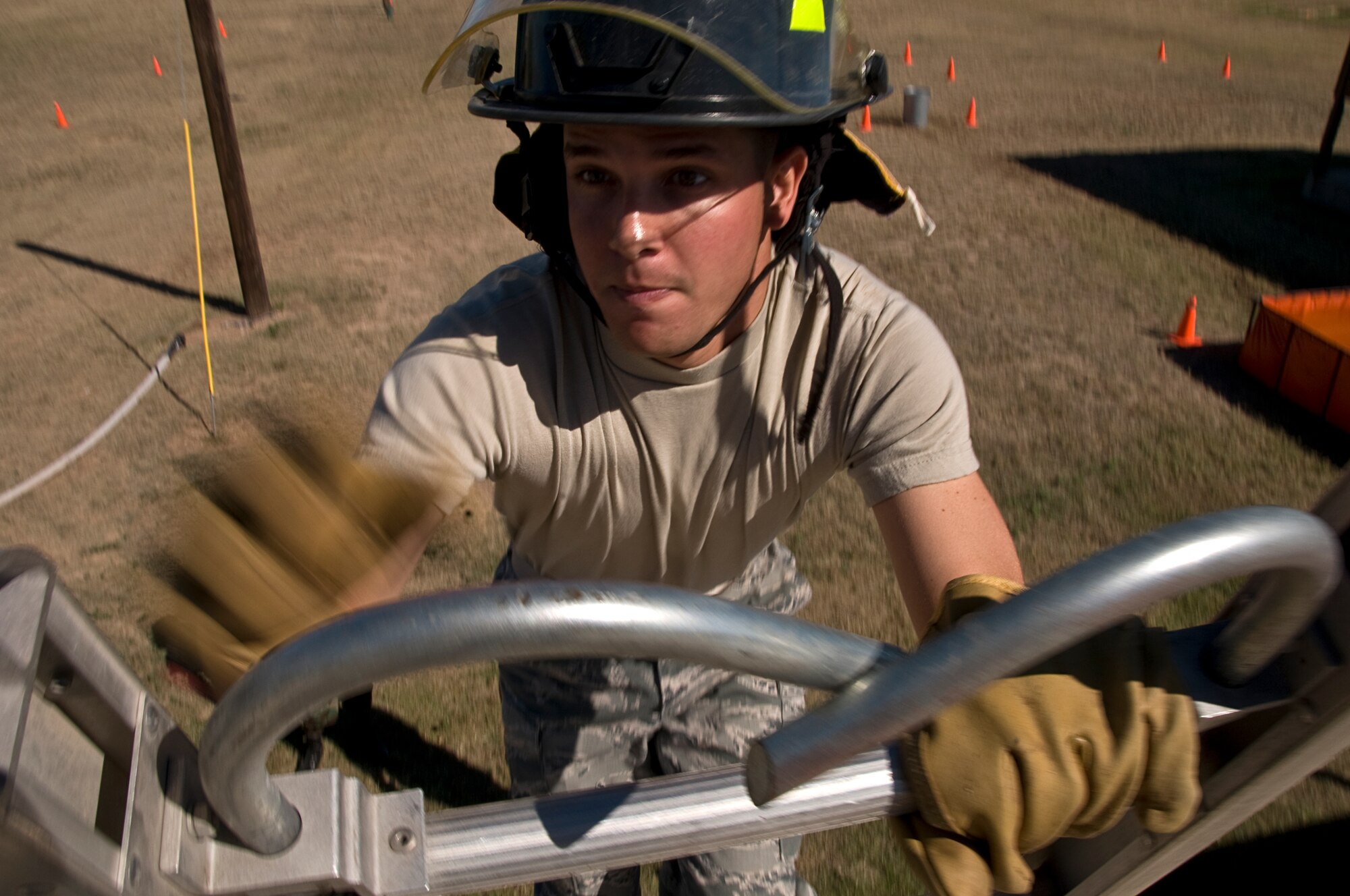 GOODFELLOW AIR FORCE BASE, Texas – Airman Basic Uvaldo Boix, 316th Training Squadron student touch the top of the ladder during the 6th annual Firefighter Muster at the fire station Oct. 8. Each member must climb every rung as well as touch the top of the ladder before the team can move to the next obstacle. (U.S. Air Force photo/ Senior Airman Tong Duong)