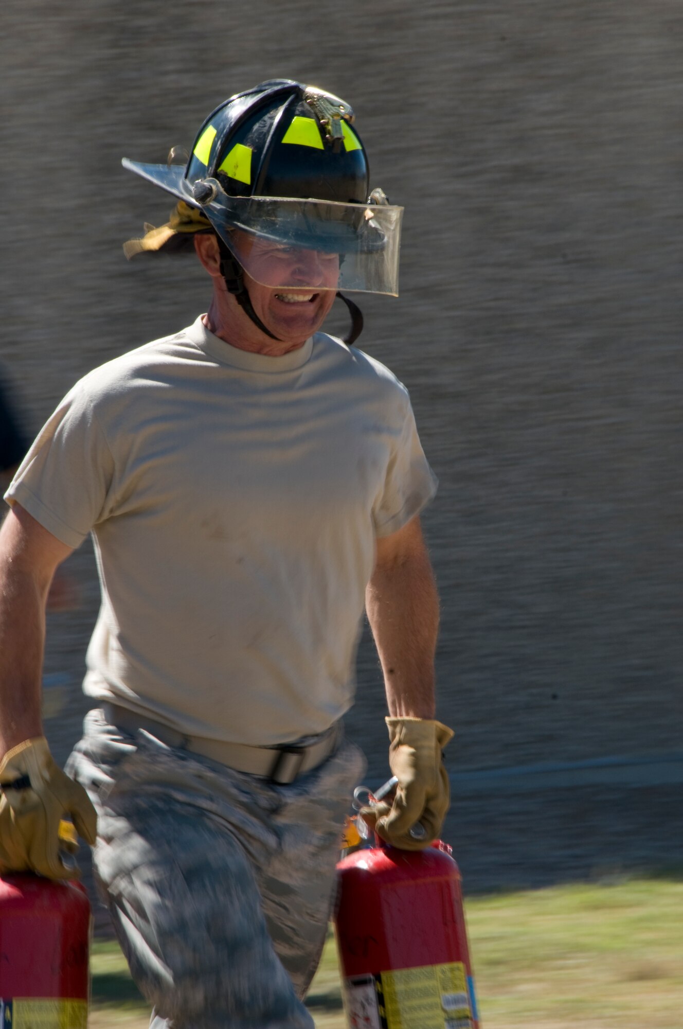GOODFELLOW AIR FORCE BASE, Texas – Col. Guy Parker, 17th Mission Support Group commander, hustles through the fire extinguisher carry course, during the 6th annual Firefighter Muster at the fire station Oct. 8. 11 teams of four competed in eight obstacles for a chance at the title, a year of bragging rights and $100 cash prize. (U.S. Air Force photo/ Senior Airman Tong Duong)