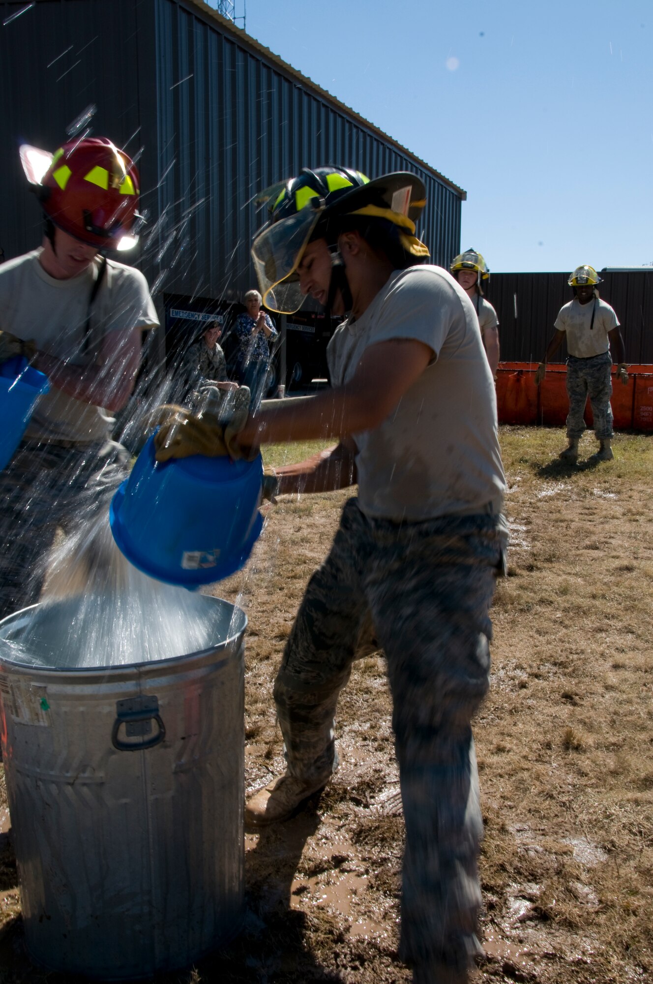GOODFELLOW AIR FORCE BASE, Texas – Members of the Get Money team dump buckets of water to splash out a ping pong ball, during the 6th annual Firefighter Muster at the fire station Oct. 8. The muster was part of the Fire Prevention Awareness Week, to spread the word on fire and smoke alarm safety. (U.S. Air Force photo/ Senior Airman Tong Duong)