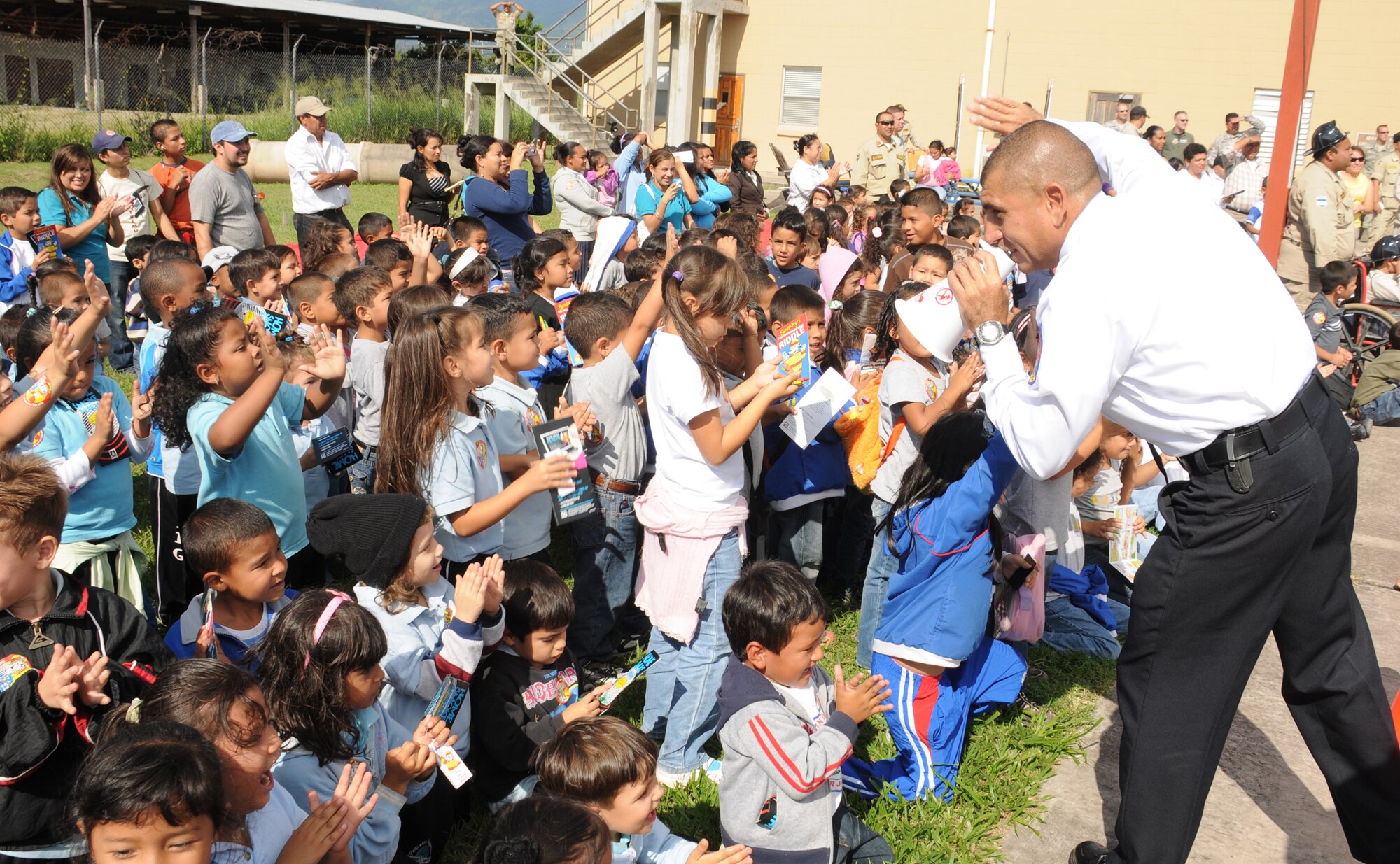 SOTO CANO AIR BASE, Honduras --   Mr. Herberth Gaekel, a civilian fire inspector with the 612th Air Base Squadron fire department here, has Comayagua school children wave good-bye to Sparky the Fire Dog during a National Fire Prevention Week event here Oct. 6. Local children and firefighters visited the base fire department to learn about fire fighting tools and fire prevention. (U.S. Air Force photo/Capt. John Stamm)