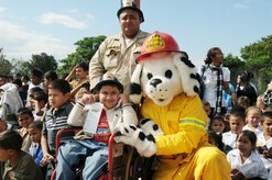 SOTO CANO AIR BASE, Honduras --  Sparky the Fire Dog takes a moment to visit with local children and firefighters during a National Fire Prevention Week celebration here Oct. 6. The 612th Air Base Squadron fire department invited the children and firefighters from the Comayagua area to not only give a demonstration of firefighter equipment, but also to teach fire prevention. (U.S. Air Force photo/Capt. John Stamm)