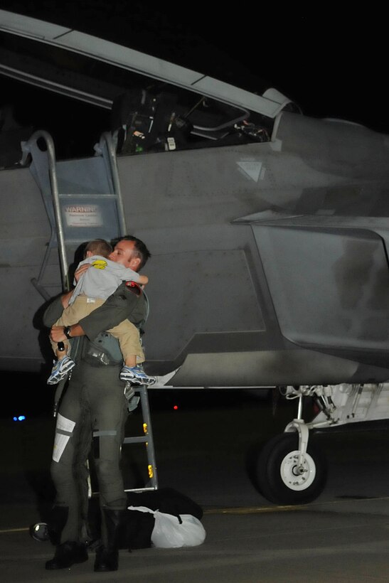 LANGLEY AIR FORCE BASE, Va -- Maj. Jeffrey Rock, 1st Fighter Wing, 27th Fighter Squadron F-22A Raptor pilot, hugs his 4-year-old son, Wyatt, after his return from Guam. A team of eight pilots from the 27th FS were deployed for four months in support of operations in the Pacific. (U.S. Air Force photo/Staff Sgt. Ashley Hawkins)(RELEASED)