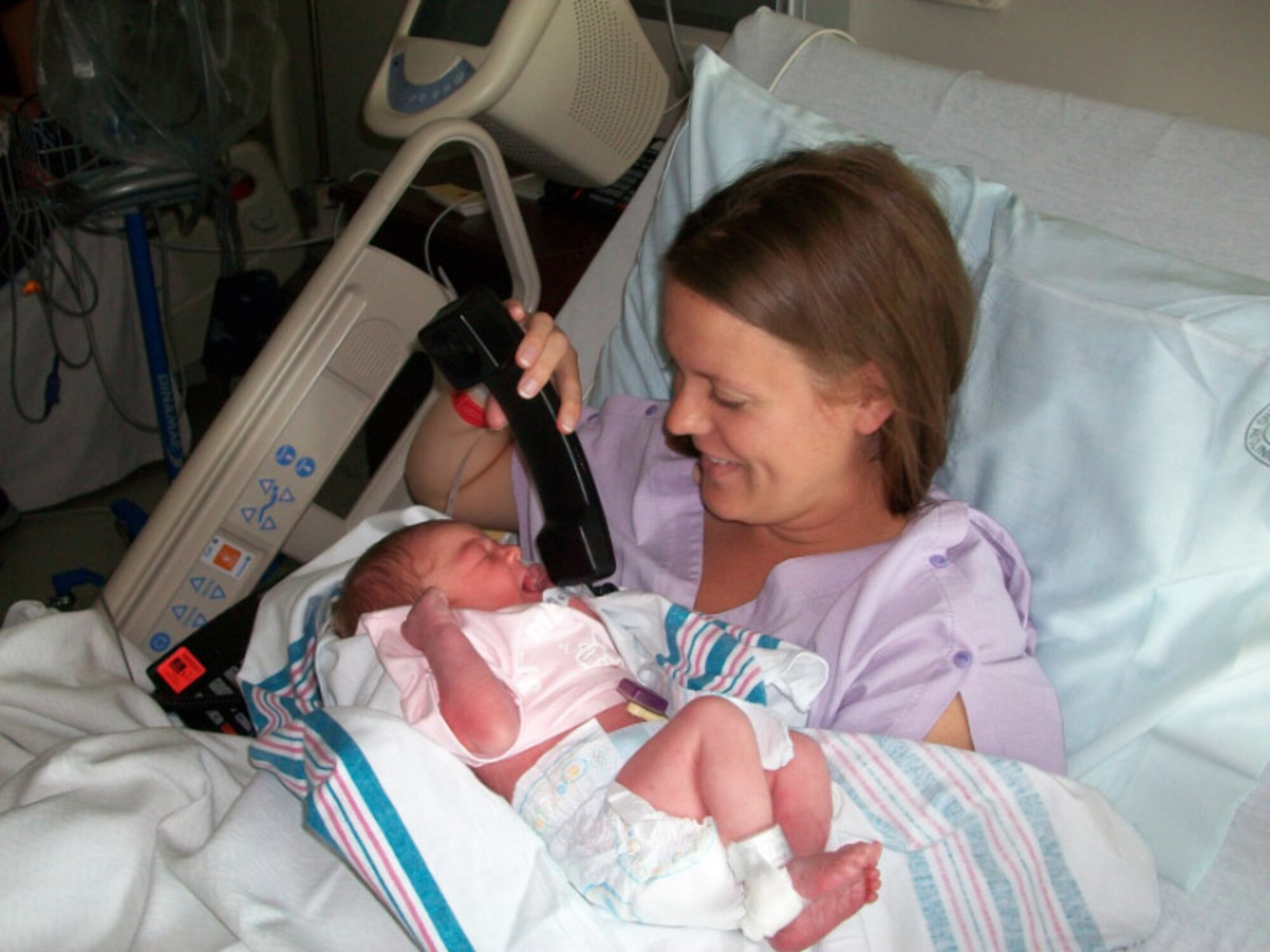 Sarah Whiddon holds a phone for her new-born daughter to “talk” to her husband, 1st Lt. William Whiddon, the 510th Fighter Squadron intelligence officer in charge at Aviano, Air Base, Italy.  At the time, he was deployed in support of Operation Enduring Freedom. (Courtesy photo)