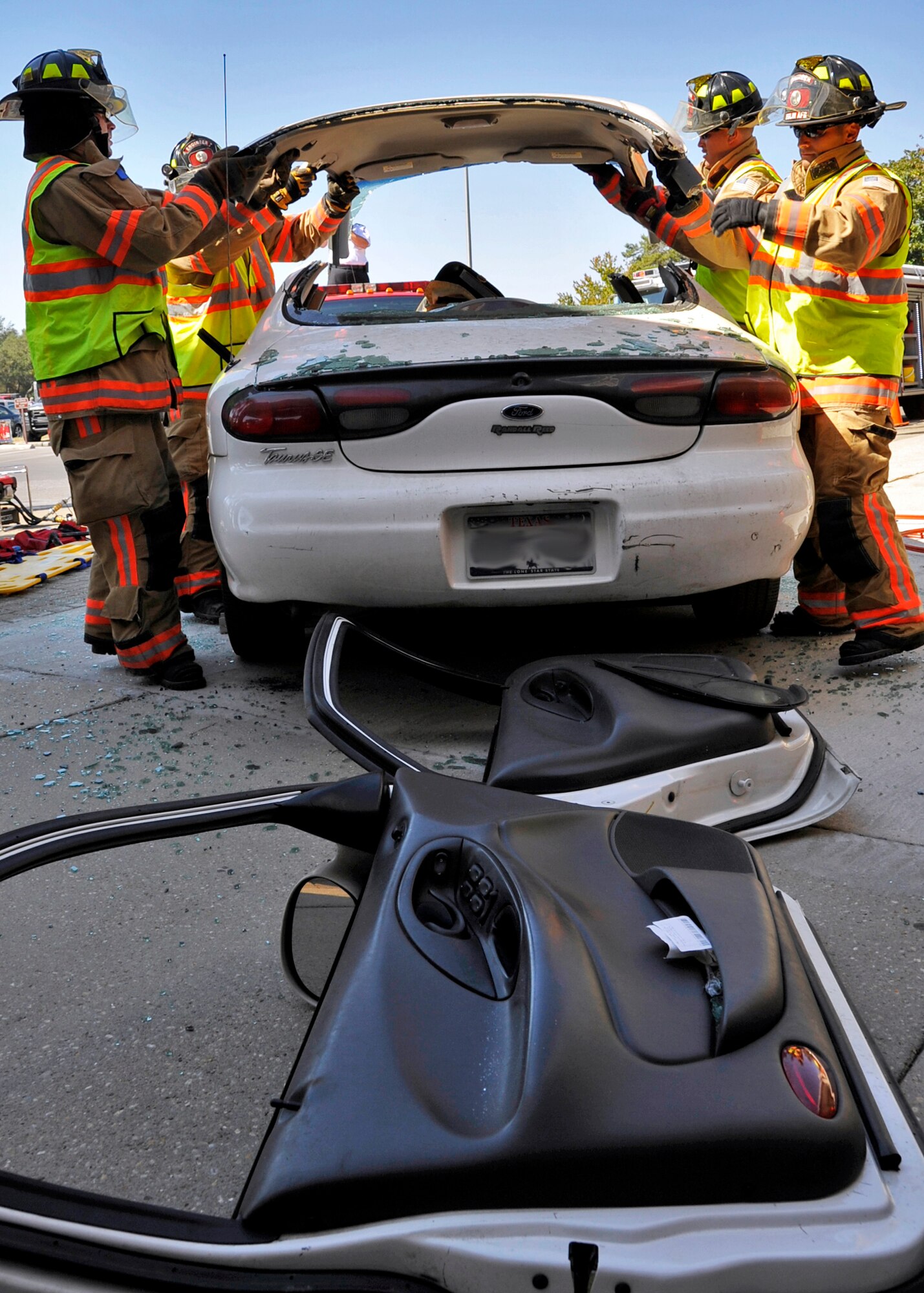 96th Civil Engineer Squadron firefighters lift the roof of the car off door during the car extraction demonstration at Eglin’s base exchange Oct.  8.  The firefighters demonstrated how quickly they can open up a car to free a trapped victim of an accident.  The demonstration closed out fire prevention week at Eglin.  (U.S. Air Force photo/Samuel King Jr.)