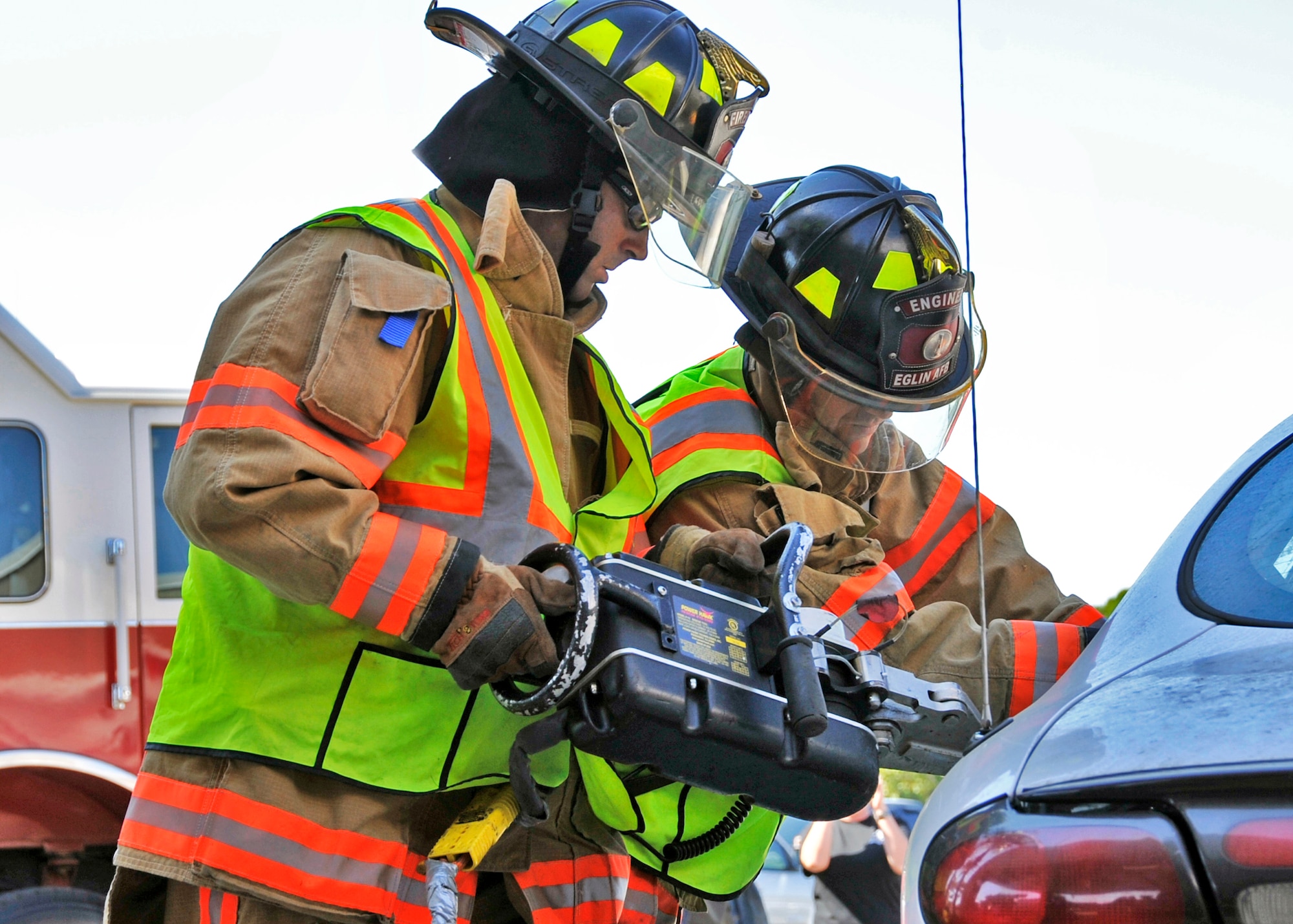 Joseph Stein and Daniel Bye, 96th Civil Engineer Squadron firefighters, open up the back seat door during the car extraction demonstration at Eglin’s base exchange Oct.  8.  The firefighters demonstrated how quickly they can open up a car to free a trapped victim of an accident.  The demonstration closed out fire prevention week at Eglin.  (U.S. Air Force photo/Samuel King Jr.)