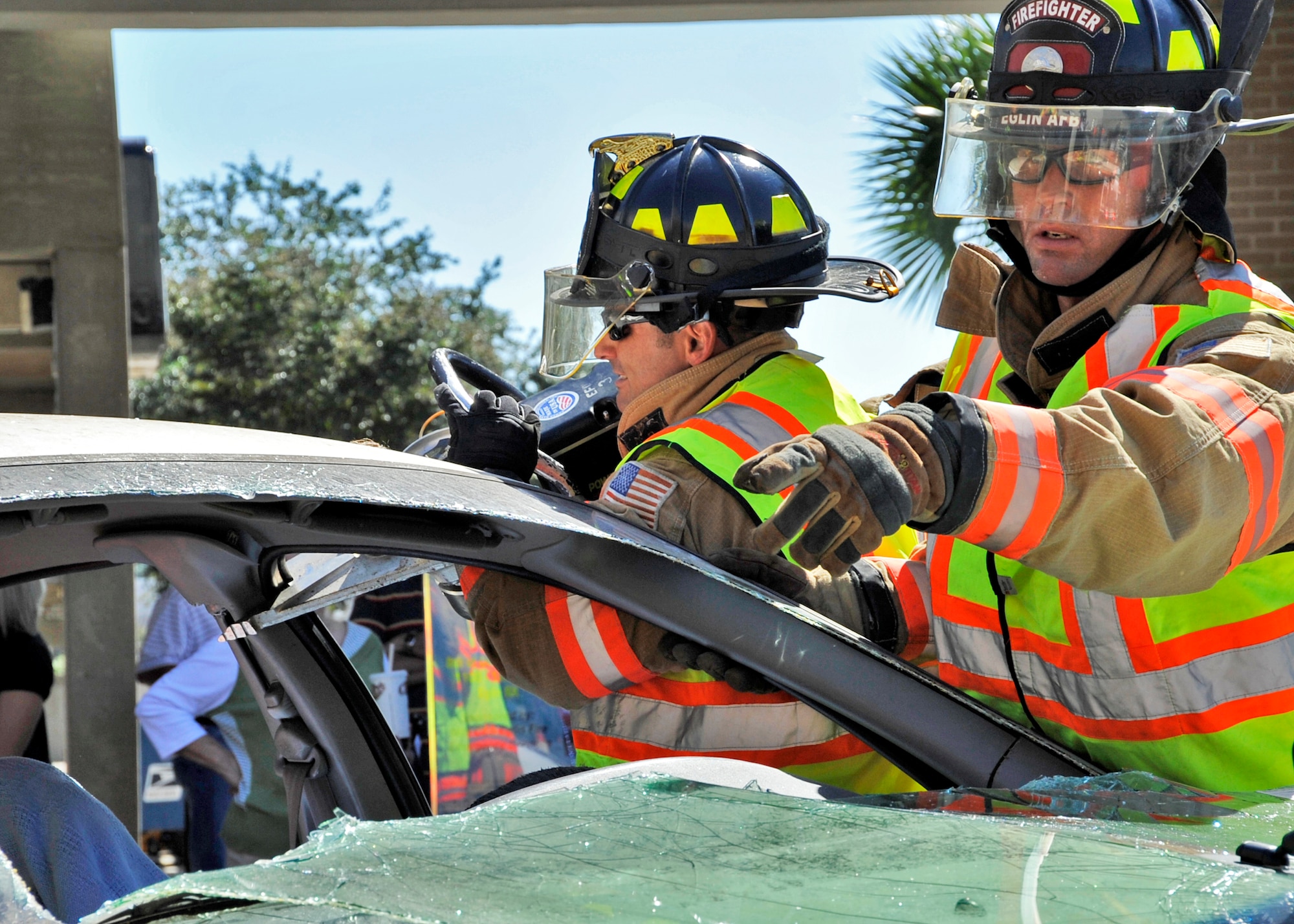 Joseph Stein, 96th Civil Engineer Squadron firefighter, calls for a piece of equipment during the car extraction demonstration at Eglin’s base exchange Oct.  8.  The firefighters demonstrated how quickly they can open up a car to free a trapped victim of an accident.  The demonstration closed out fire prevention week at Eglin.  (U.S. Air Force photo/Samuel King Jr.)