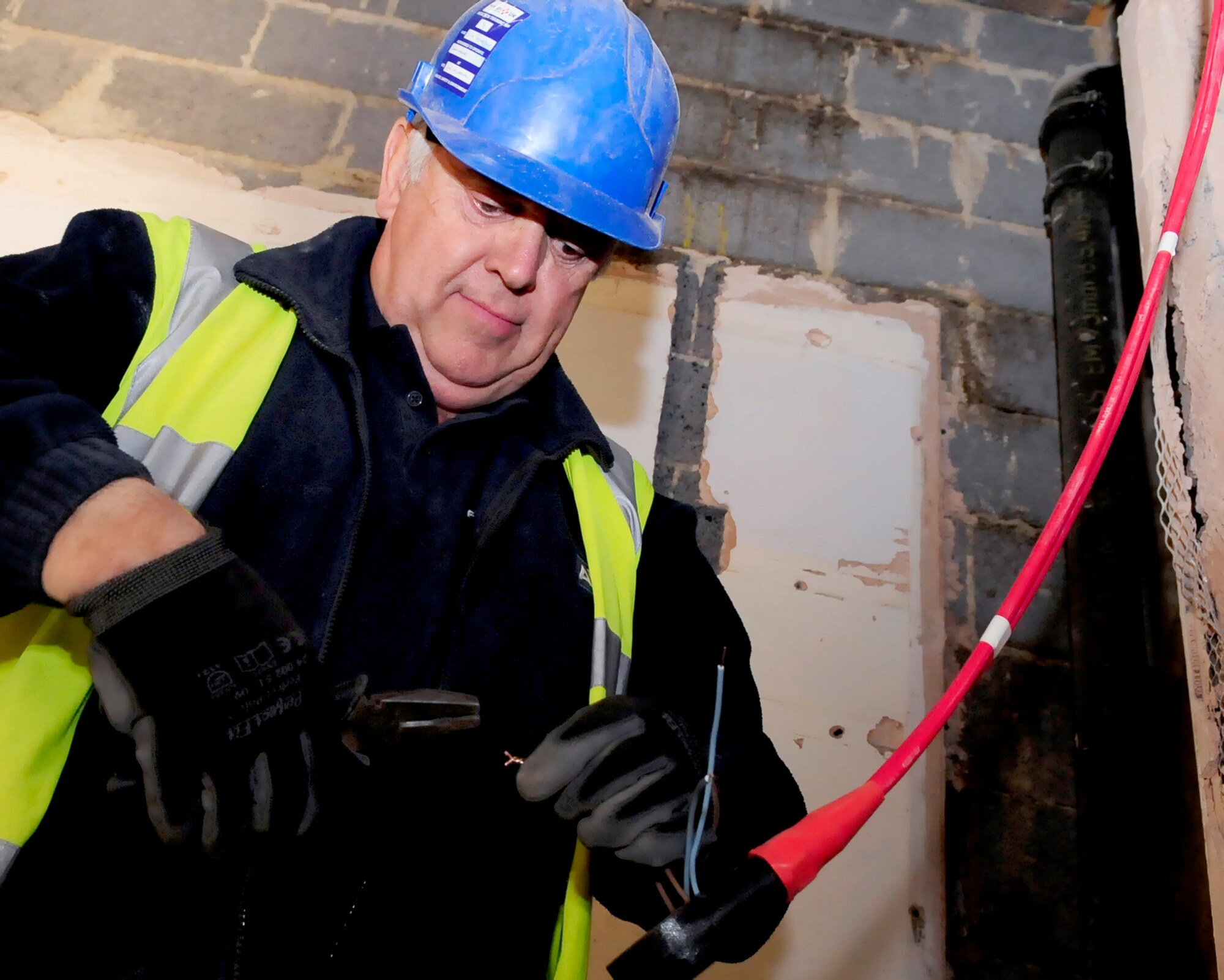 RAF MILDENHALL, England -- David Freestone, a local contractor, rewires an automatic fire alarm system during the remodeling at Building 210 here Oct. 12. The remodeling of the dorms is a quality of life upgrade to allow each resident their own bathroom. (U.S. Air Force photo/Senior Airman Ethan Morgan) 