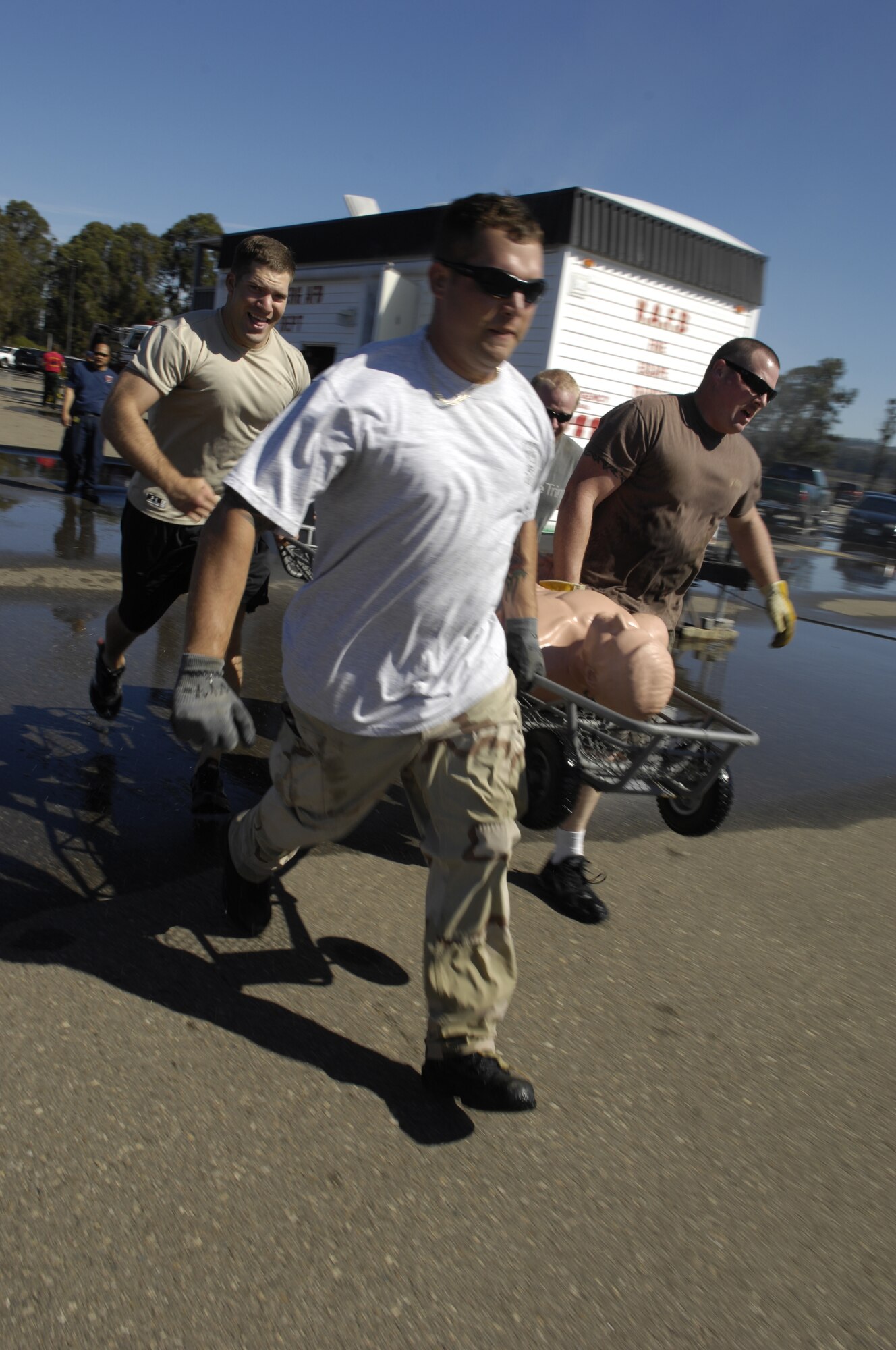 VANDENBERG AIR FORCE BASE, Calif. – Team Dirt Boyz, of the 30th Civil Engineer Squadron, carry a basket litter and dummy to a designated point on an obstacle course at this year’s Fire Muster at the base parade grounds Friday, Oct. 8, 2010. The Fire Muster competition is held every year to demonstrate what a firefighter faces physically and gives base units a chance to compete against one another. (U.S. Air Force photo/Airman 1st Class Lael Huss)