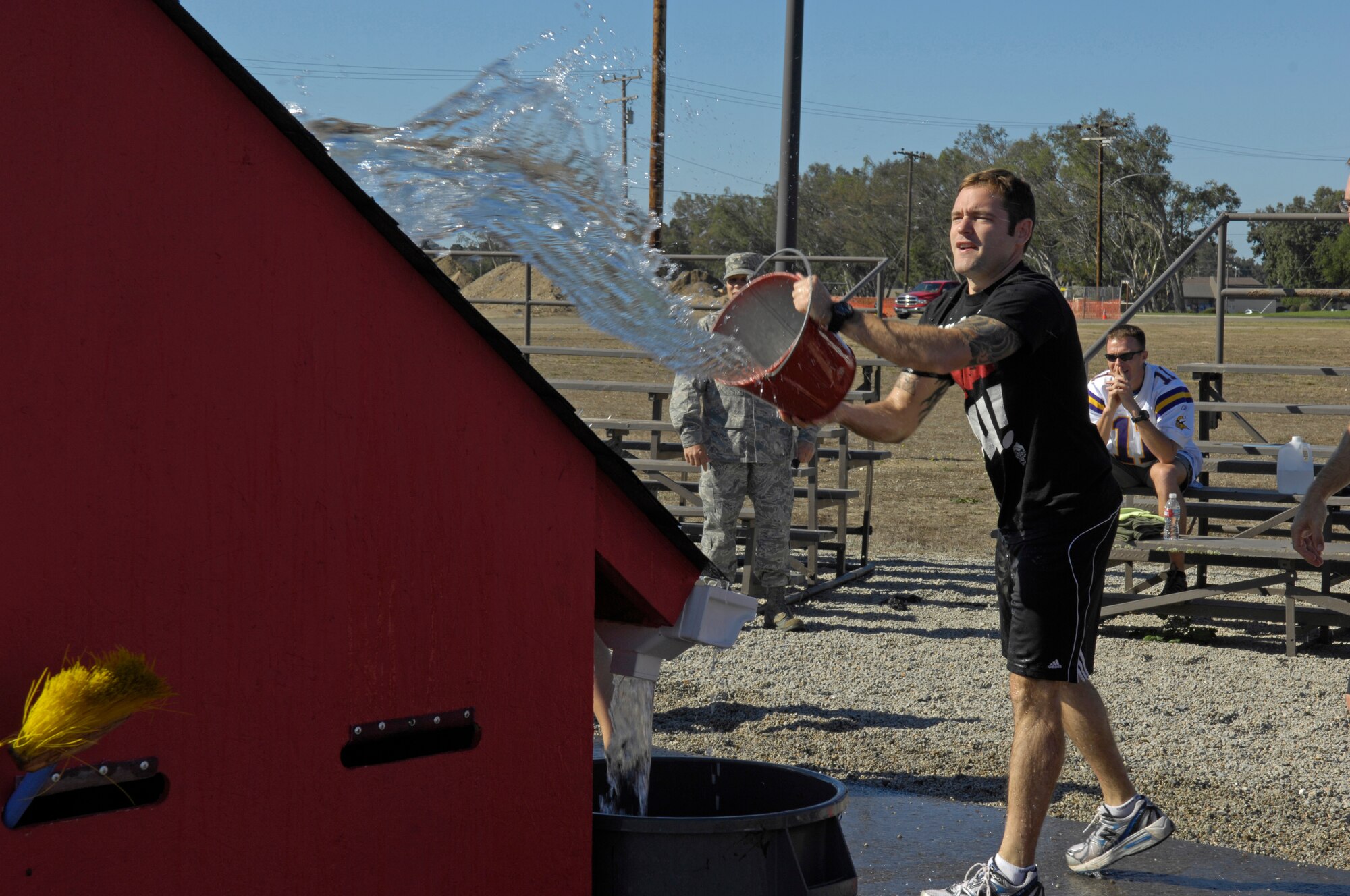 VANDENBERG AIR FORCE BASE, Calif. – Senior Airman Tristan Weghorn, from the 614th Air and Space Operations Center, tosses water onto a roof for the bucket brigade portion of the Fire Muster here Friday, Oct. 8, 2010. The Fire Muster is an annual competition between squadrons at the base parade grounds. (U.S. Air Force photo/Airman 1st Class Lael Huss)
