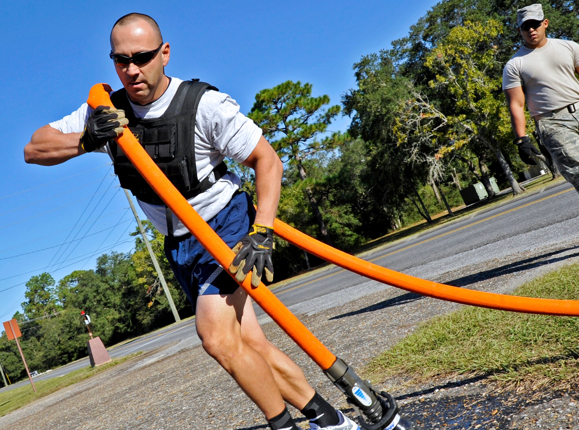 Master Sgt. Chuck Veillon, 33rd Aircraft Maintenance Squadron, throws the fire hose onto his shoulder during the first sergeants vs commanders’ challenge Oct. 7 at Eglin Air Force Base, Fla.  The challenge represented the physical training course new Airmen must accomplish to become Air Force firefighters.  The course included hose carrying, dragging and pulling, victim carry and climbing 10 steps up a ladder five times and more.   The shirts beat the commanders for a second year by a full minute with a combined time of 18 minutes, 11 seconds.   (U.S. Air Force photo/Samuel King Jr.)