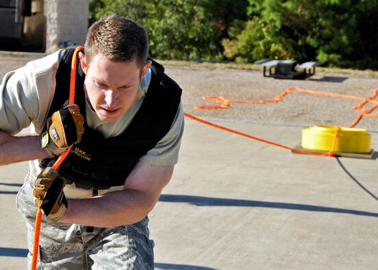 Maj. David Osterman, 96th Ground Combat Training Squadron, pulls a hose back to the line during the first sergeants vs commanders’ challenge Oct. 7 at Eglin Air Force Base, Fla.  The challenge represented the physical training course new Airmen must accomplish to become Air Force firefighters.  The course included hose carrying, dragging and pulling, victim carry and climbing 10 steps up a ladder five times and more.   The shirts beat the commanders for a second year by a full minute with a combined time of 18 minutes, 11 seconds.   (U.S. Air Force photo/Samuel King Jr.)